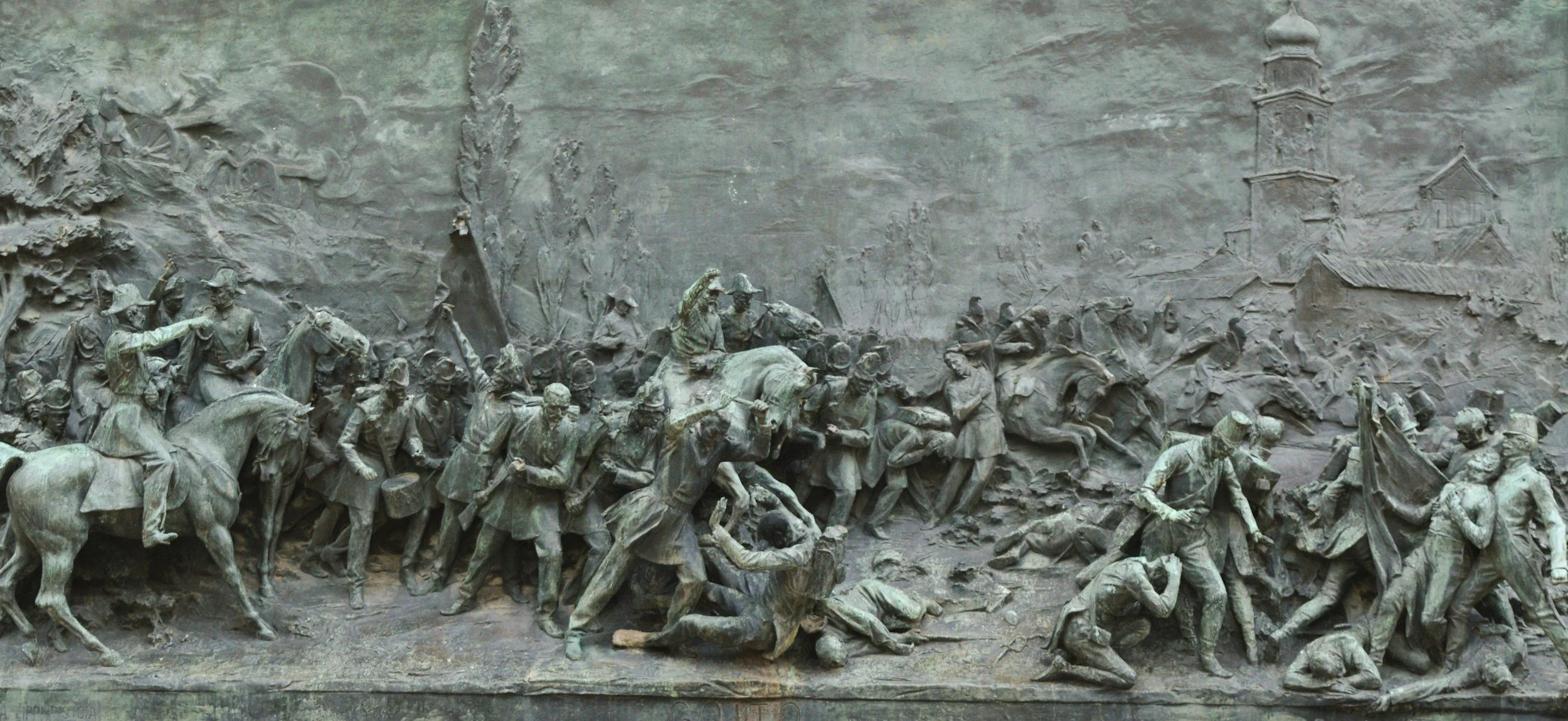 Bronze relief sculpture depicting a historical battle scene with soldiers and horses in action, featuring detailed and intricate carvings.