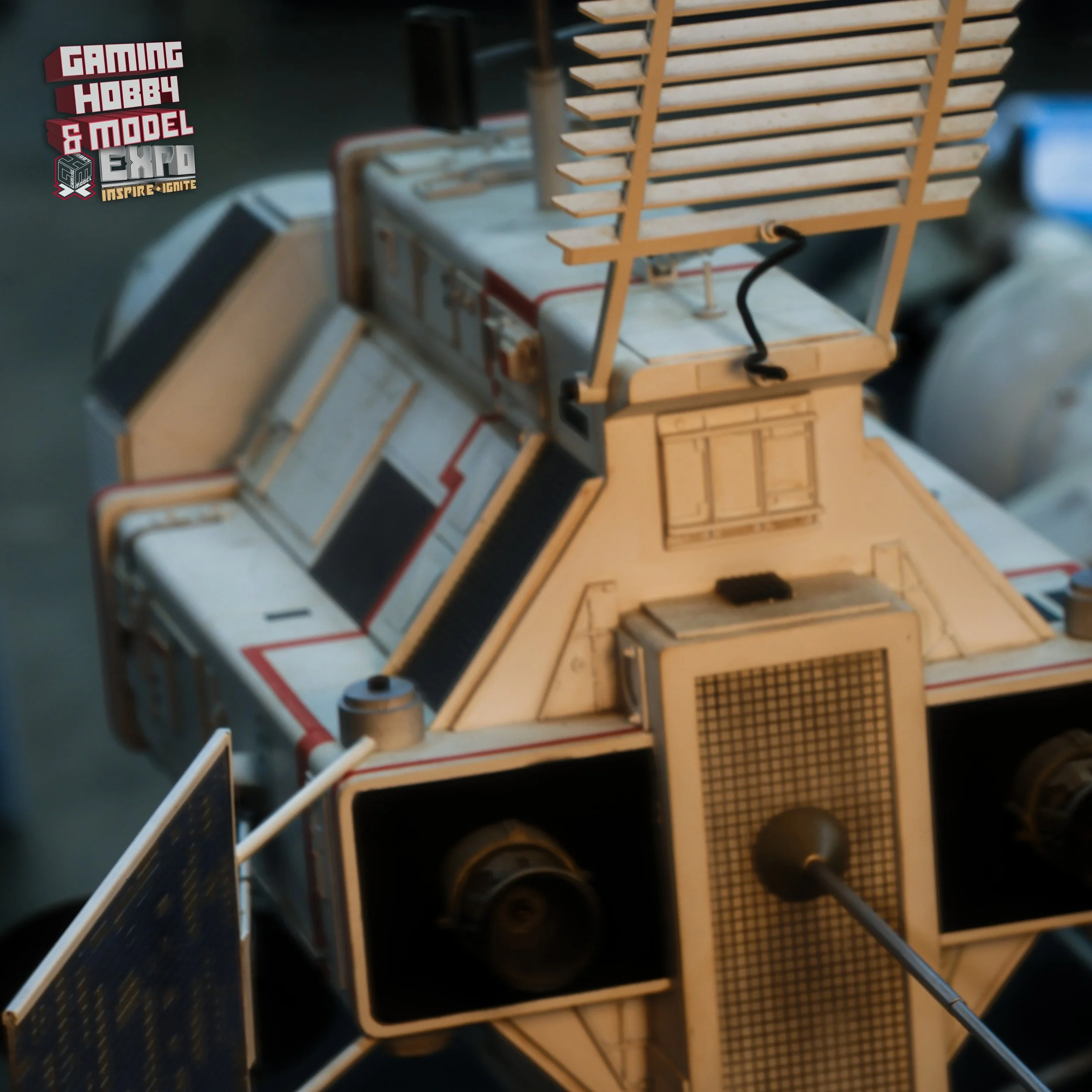 Close-up of a model of the Apollo Lunar Module, showing details like antennas and solar panels, with a gaming hobby and model expo logo in the corner.