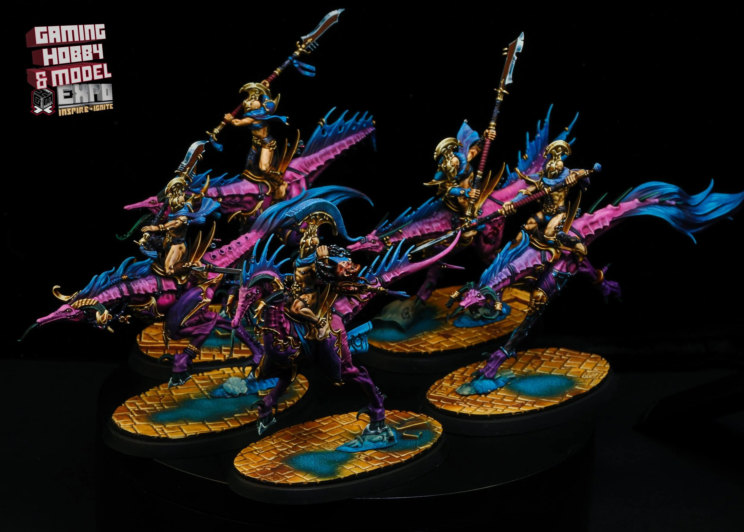 A set of fantasy miniatures with armored warriors riding purple and blue dragon-like creatures, set on painted bases resembling bricks and water.