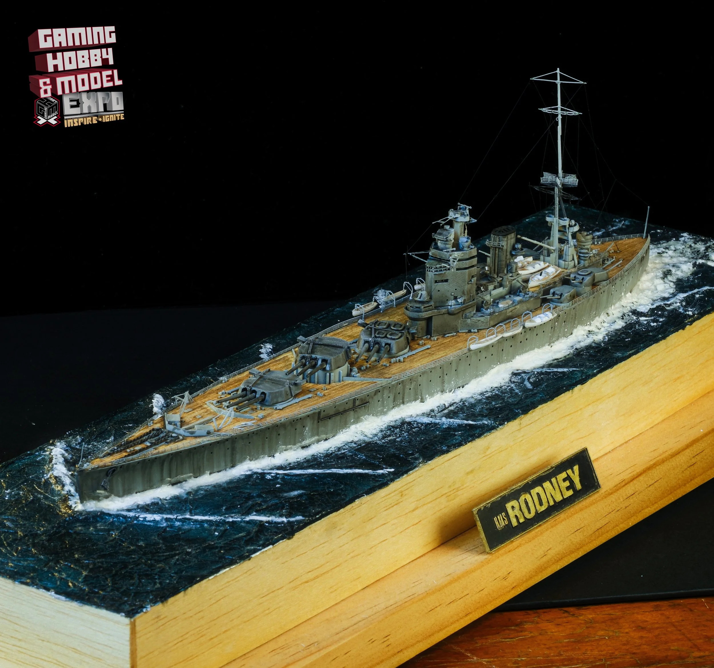 Detailed wooden model of the USS Rodney battleship displayed on a wooden base with a plaque.