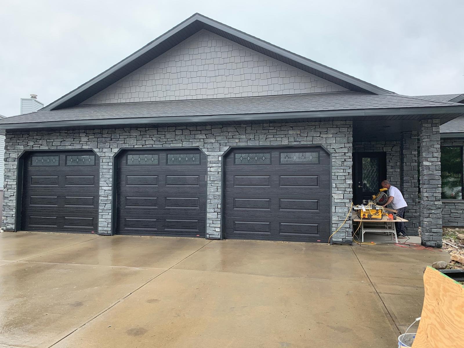House on a hillside with snowy mountains in the background.