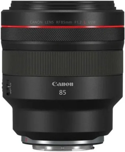 A Canon RF85mm F1.2L USM camera lens, black with red accent, resting on a gray surface.