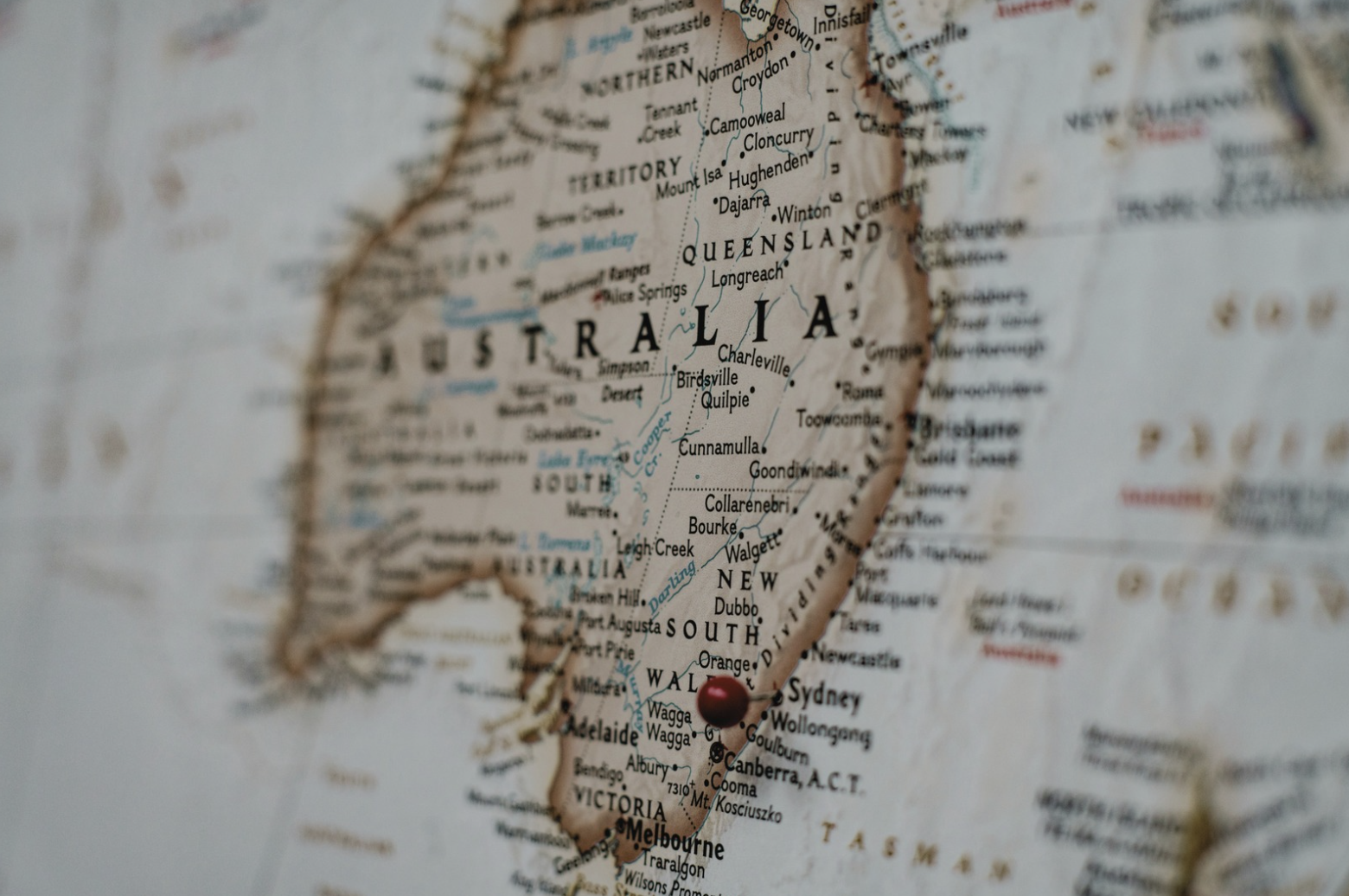 Close-up of a map of Australia with a red pushpin marking a location in the southeastern part of the country.