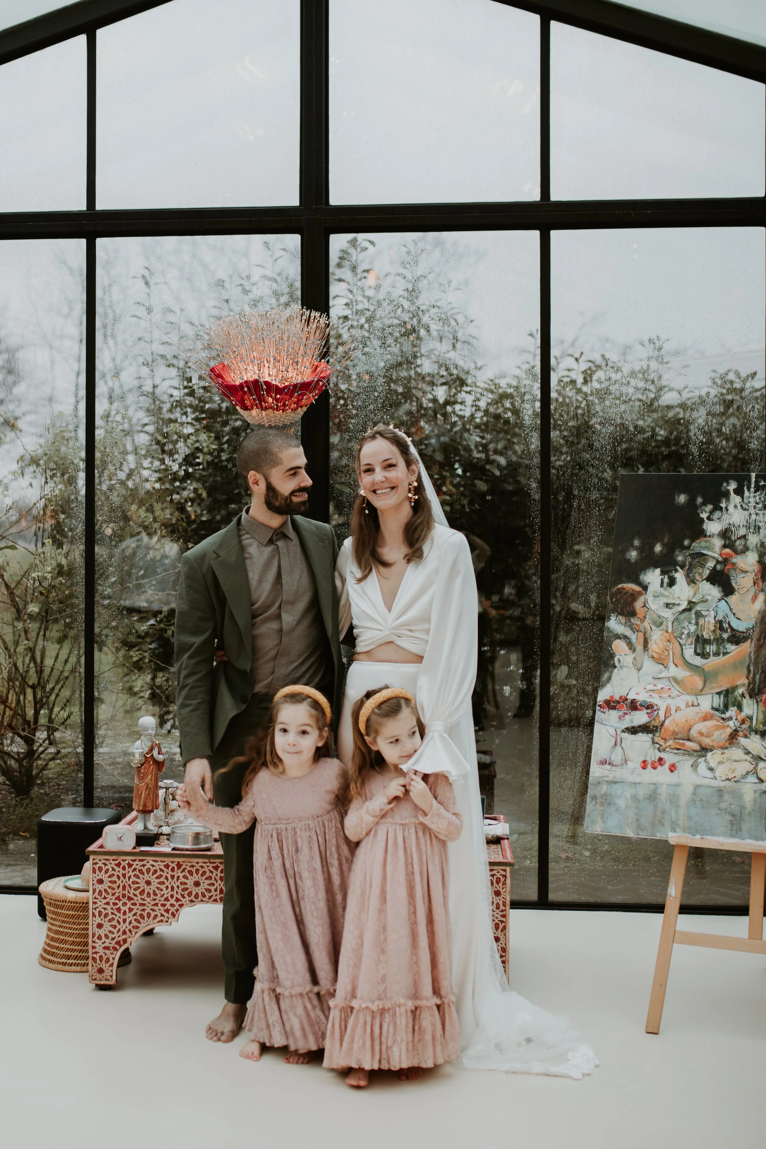 A wedding celebration with a bride, groom, two young girls, and various decorations.