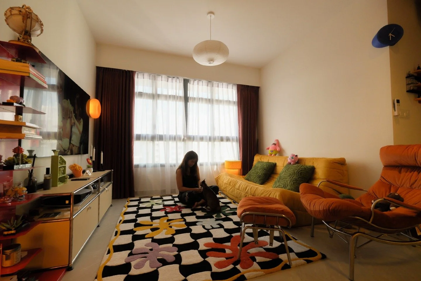The room that started with a rug.

The graphic rug takes up the floor and sets the tone for everything around it, bold, colourful, and completely unafraid. A mustard yellow sofa, an orange lounge chair, shelves packed with things that matter, and som