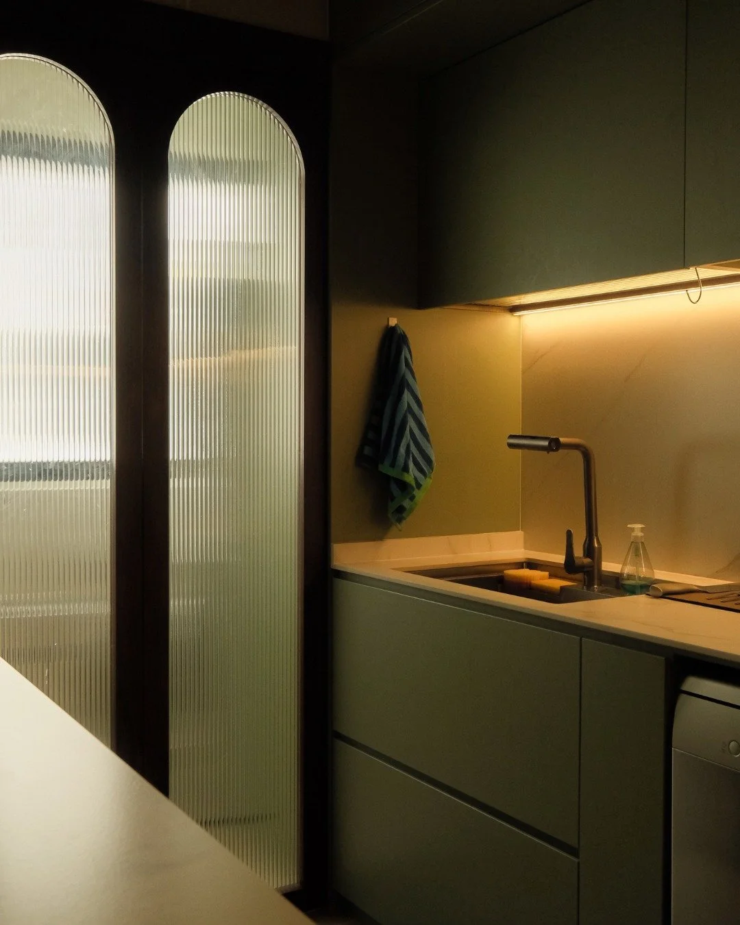 The door was never part of the plan.

But the ID saw what the homeowner couldn't yet. Twin arched fluted glass panels now close off the service yard from neighbouring sightlines while still letting light filter through, turning a purely practical dec
