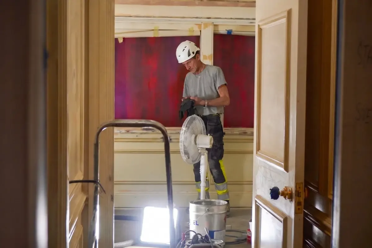 Marine worker applying protective coating to a ship interior