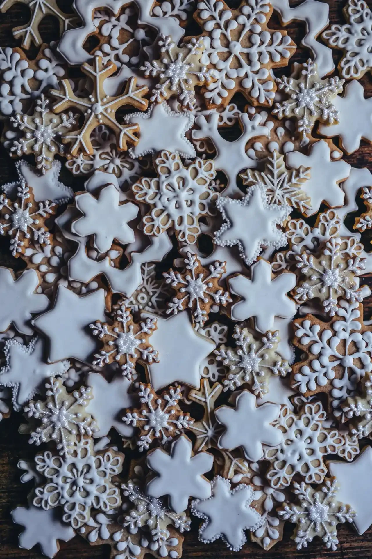 multiple christmas snowflake cookies decorated by hand 