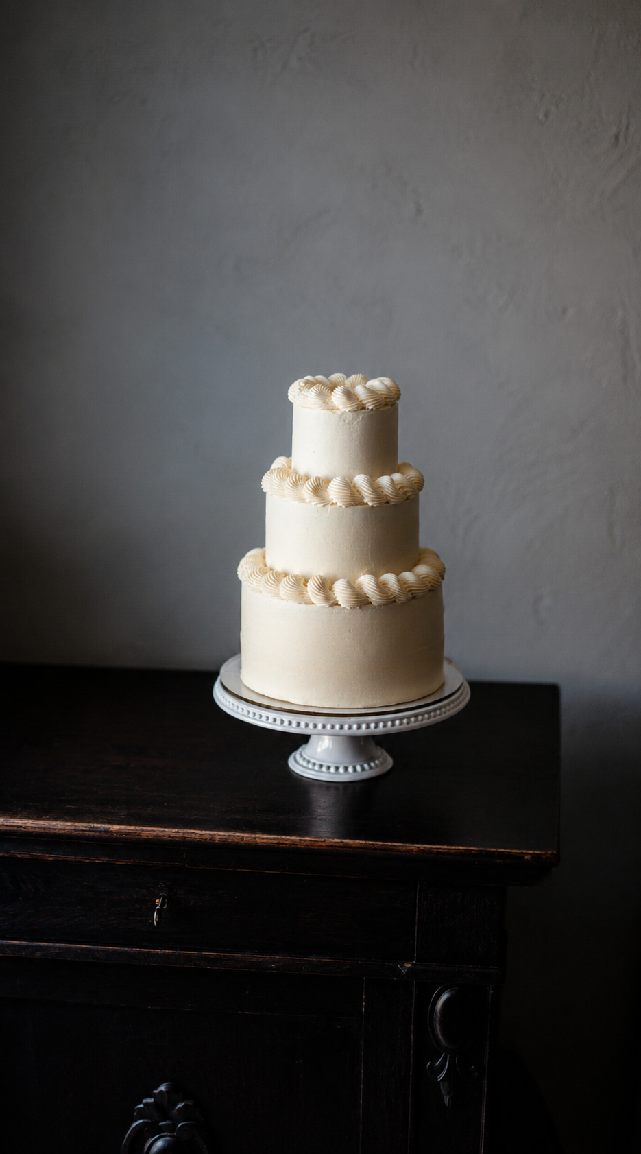 Classic three-tier white wedding cake with delicate piped buttercream details