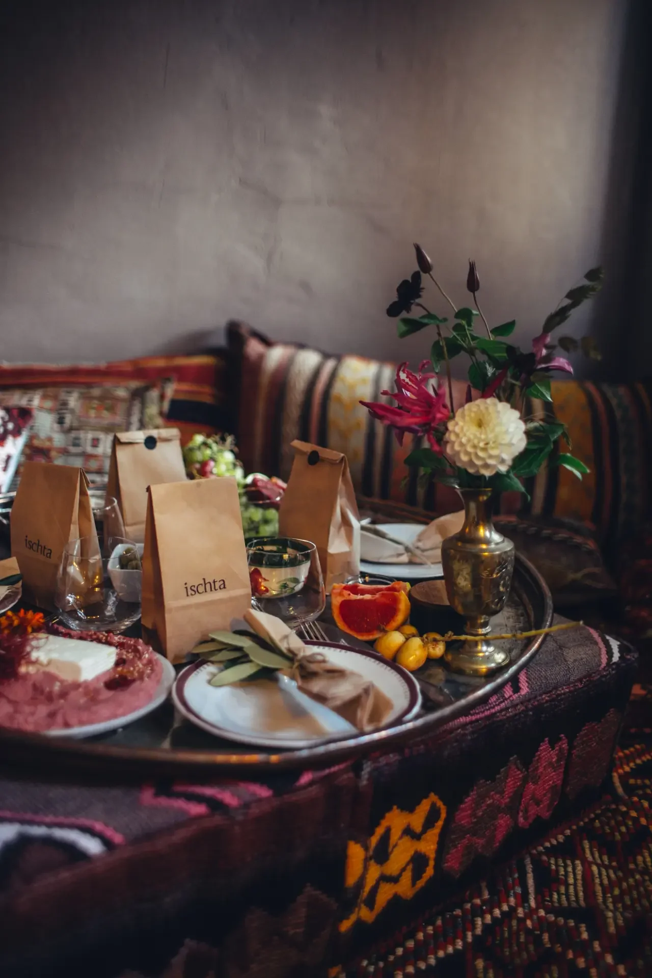 Artisan breakfast tray with Turkish tea, seasonal fruits and colorful mezze on woven textiles