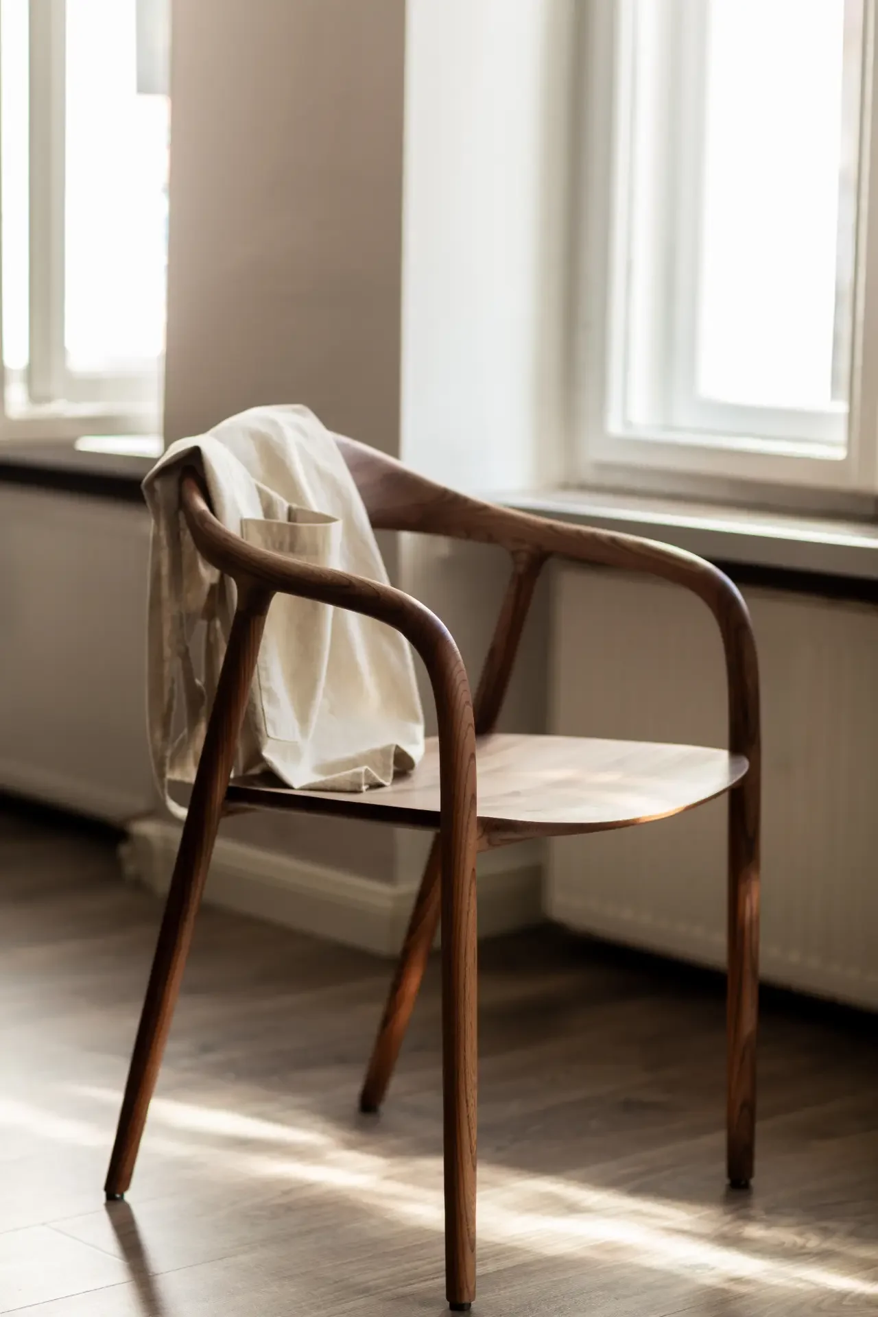 Minimal wooden chair in sunlit corner of Dilekerei studio interior