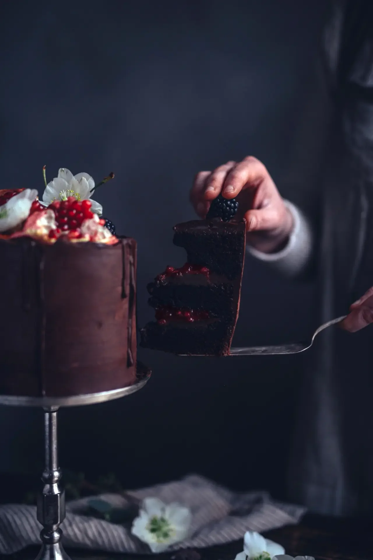 Slice of chocolate cake with pomegranate garnish and rich chocolate layers
