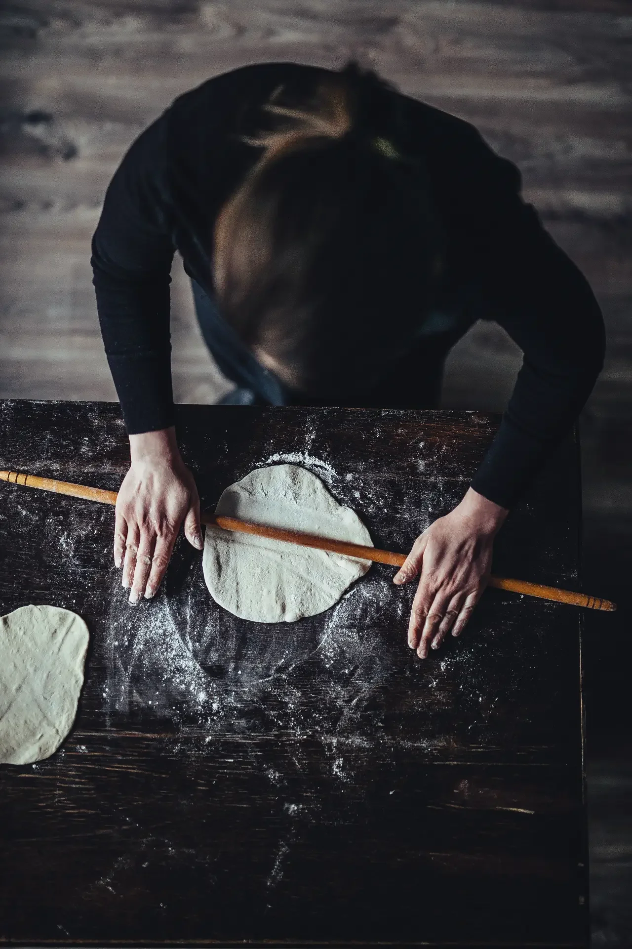 Artisan flatbread dough prepared by hand on rustic baking surface
