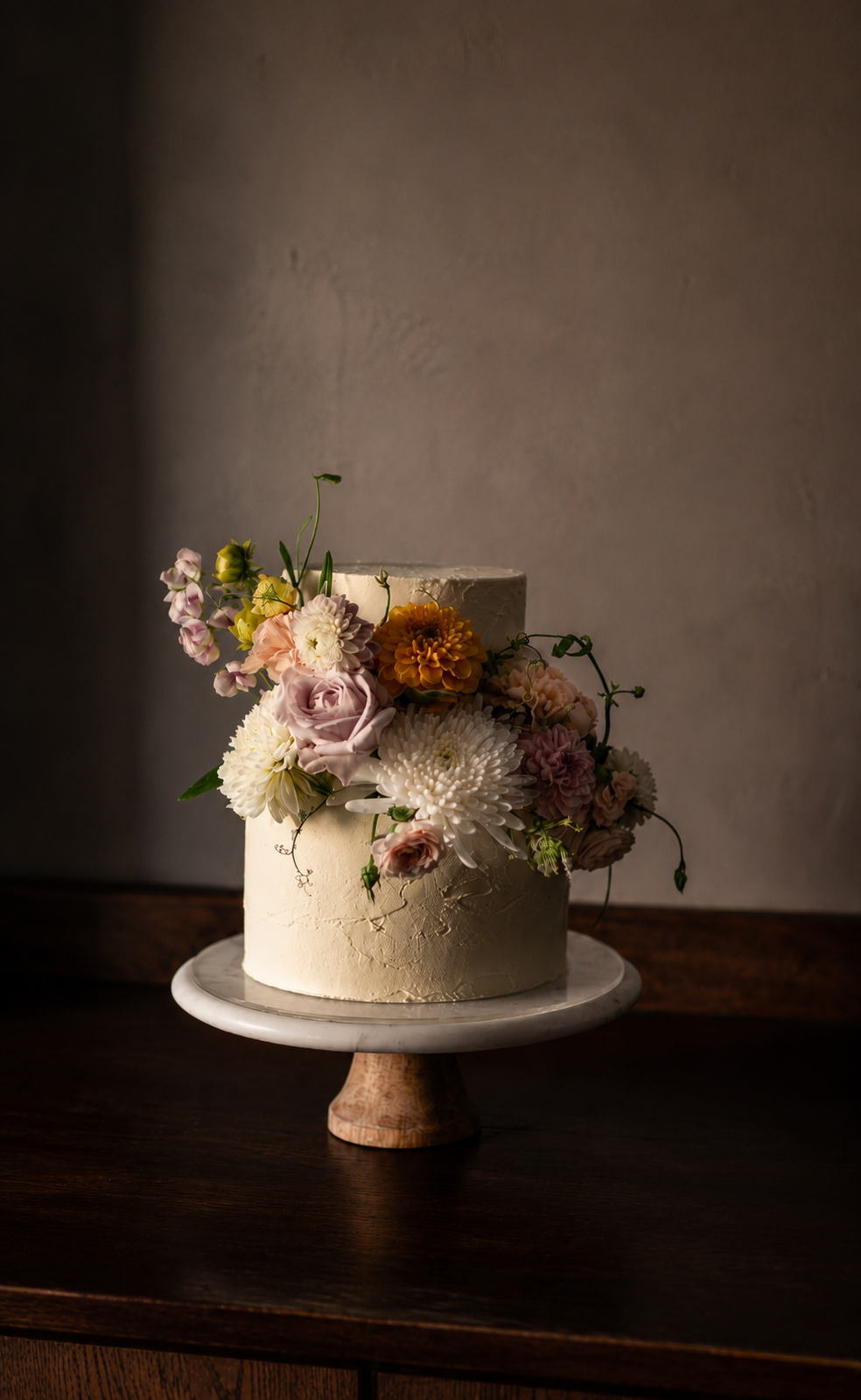Romantic two-tier floral wedding cake decorated with fresh seasonal flowers by dilekerei Berlin