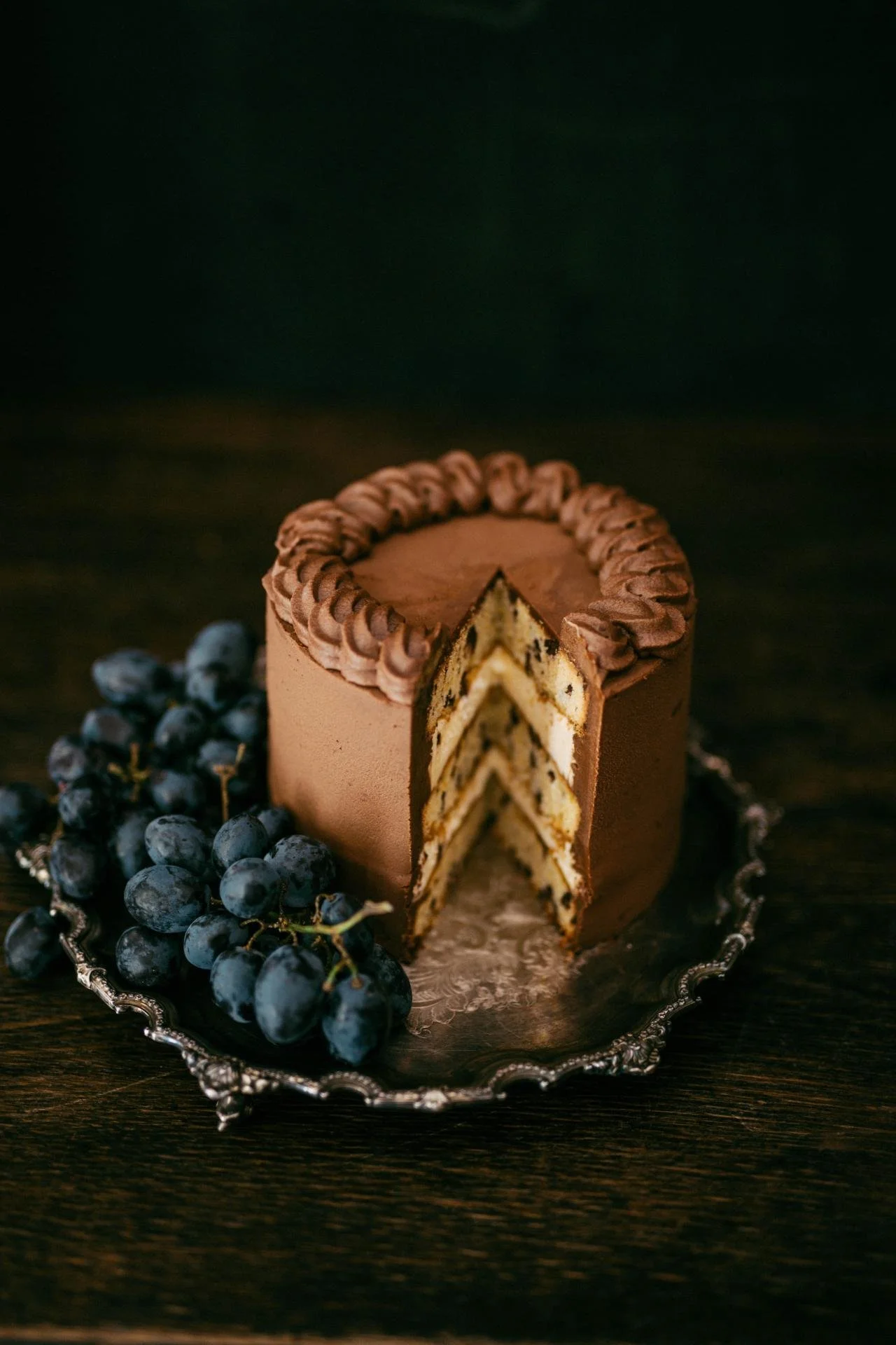 Chocolate layer cake with chocolate frosting and fresh grapes