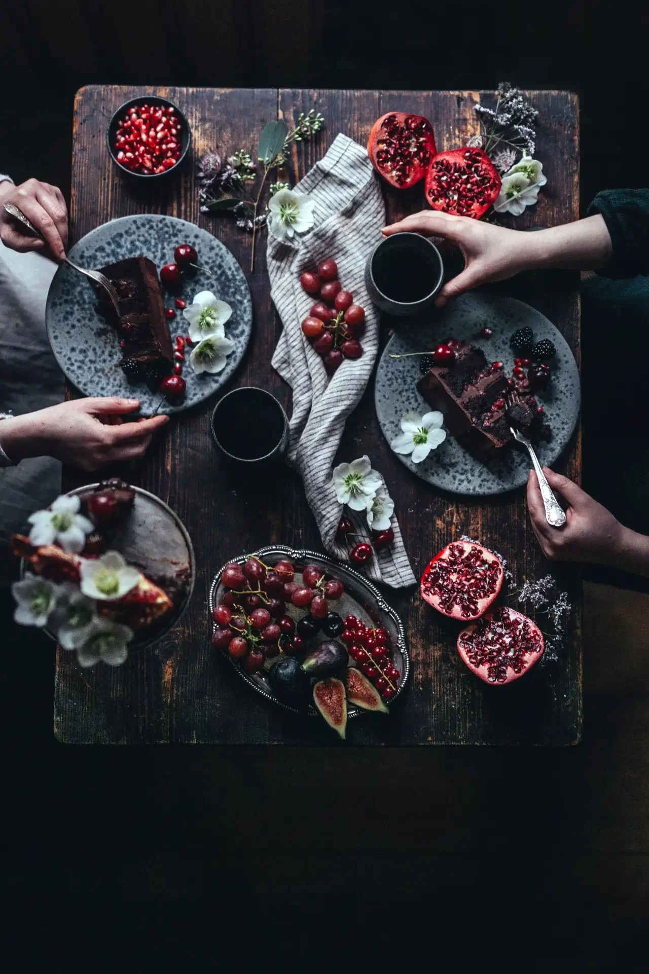 Gathering around chocolate pomegranate cake with tea and seasonal fruit