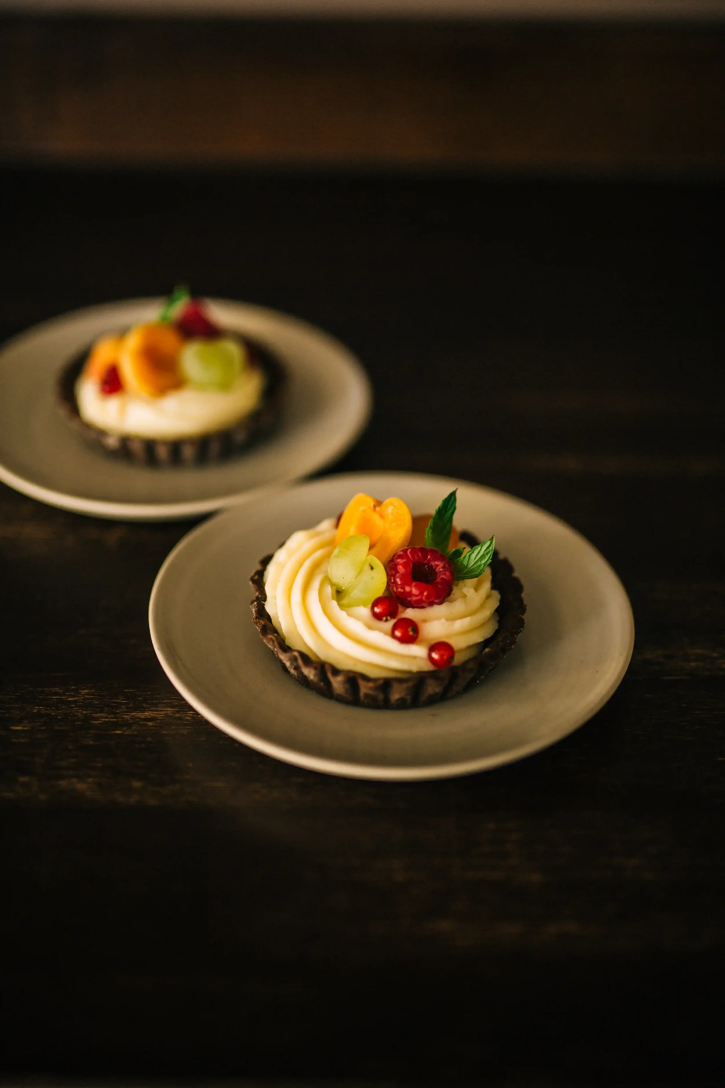 Individual fruity cheesecake tarte with fresh fruit and cream cheese frosting