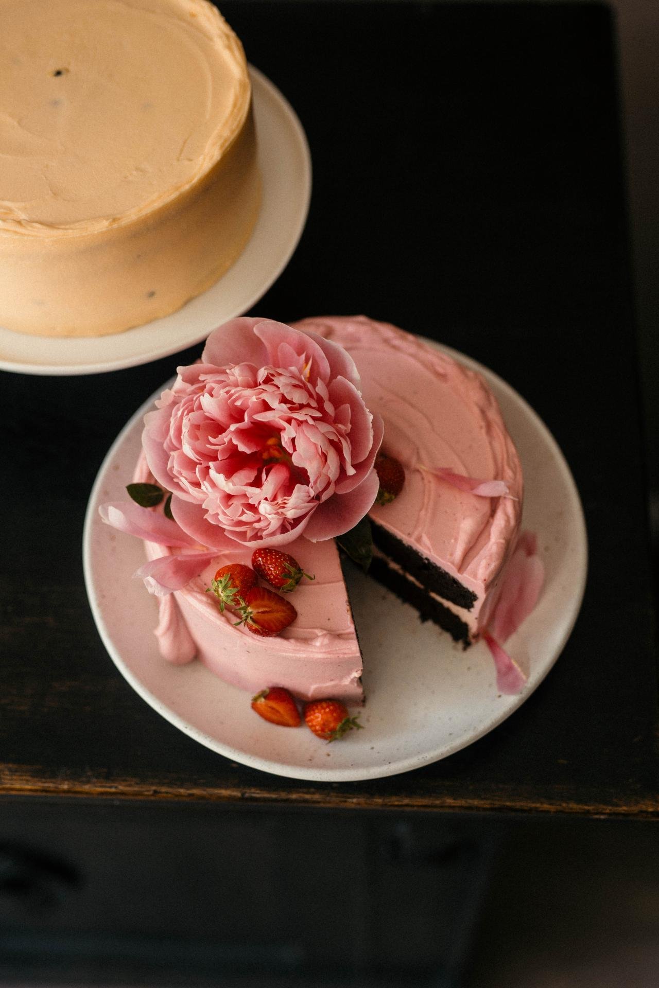 Pink celebration cake with fresh flower decoration served by the slice