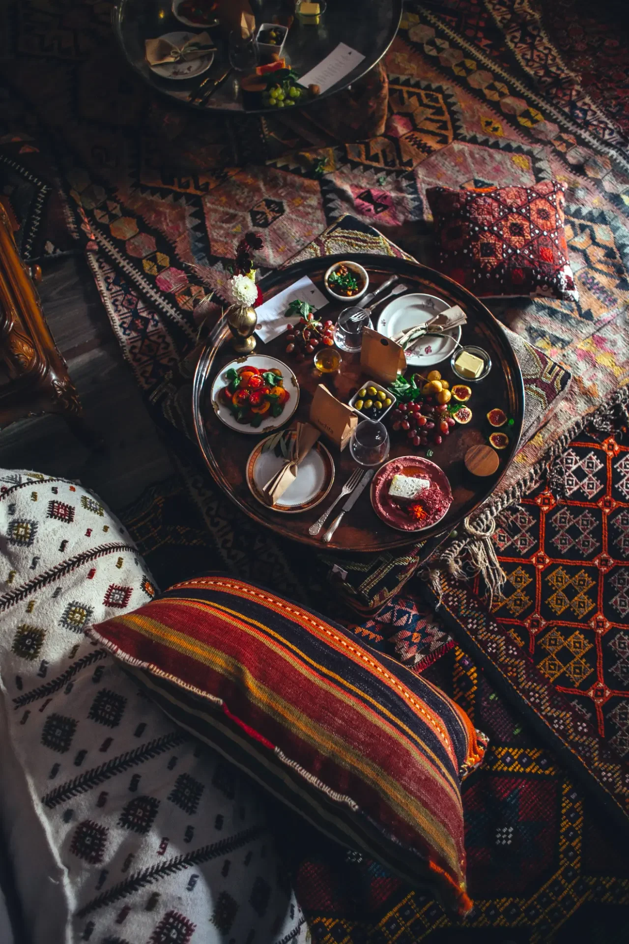 Mediterranean breakfast spread with dips, fresh fruit and tea served on traditional Turkish carpets