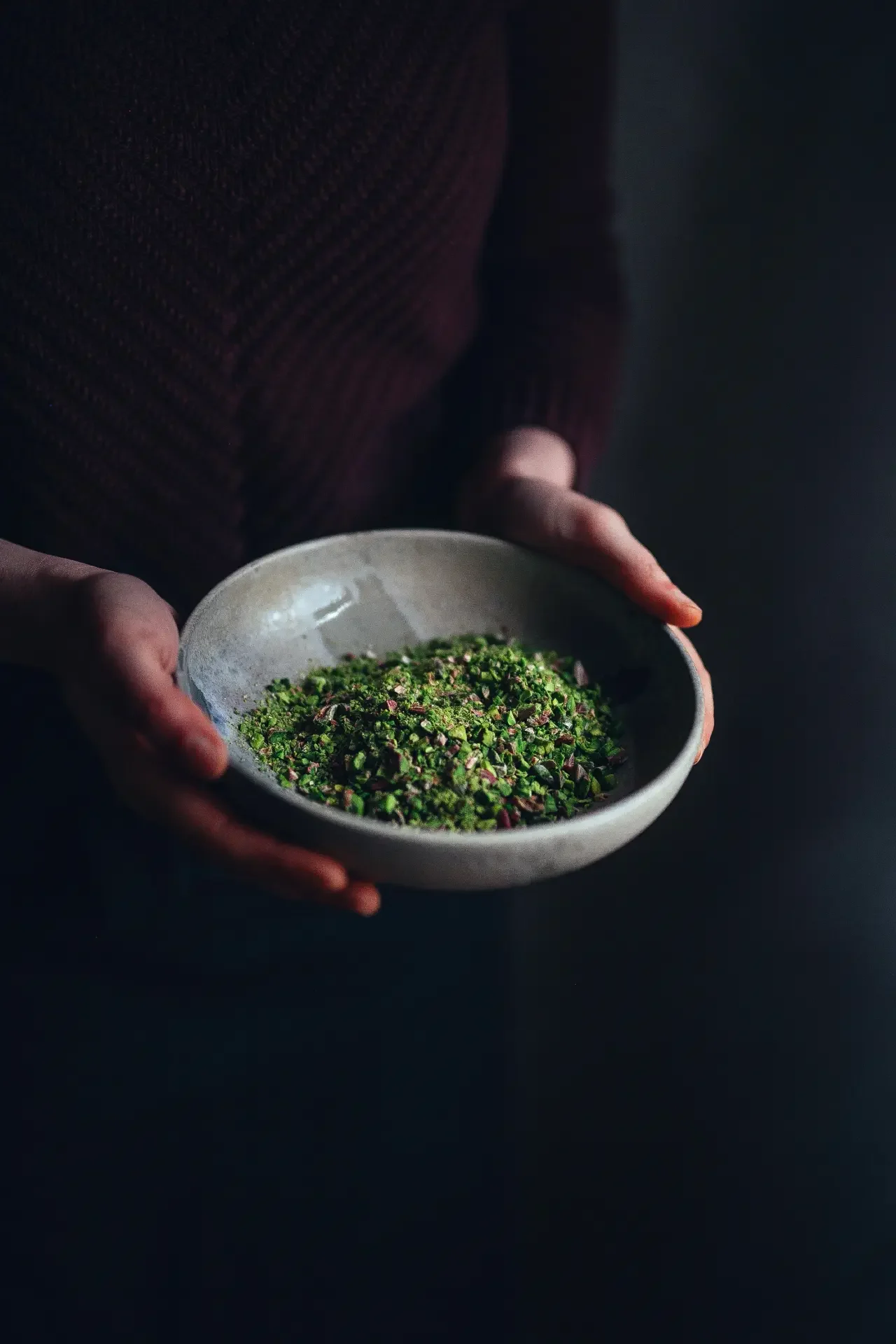 Hand holding chopped pistachios for traditional Turkish delight preparation
