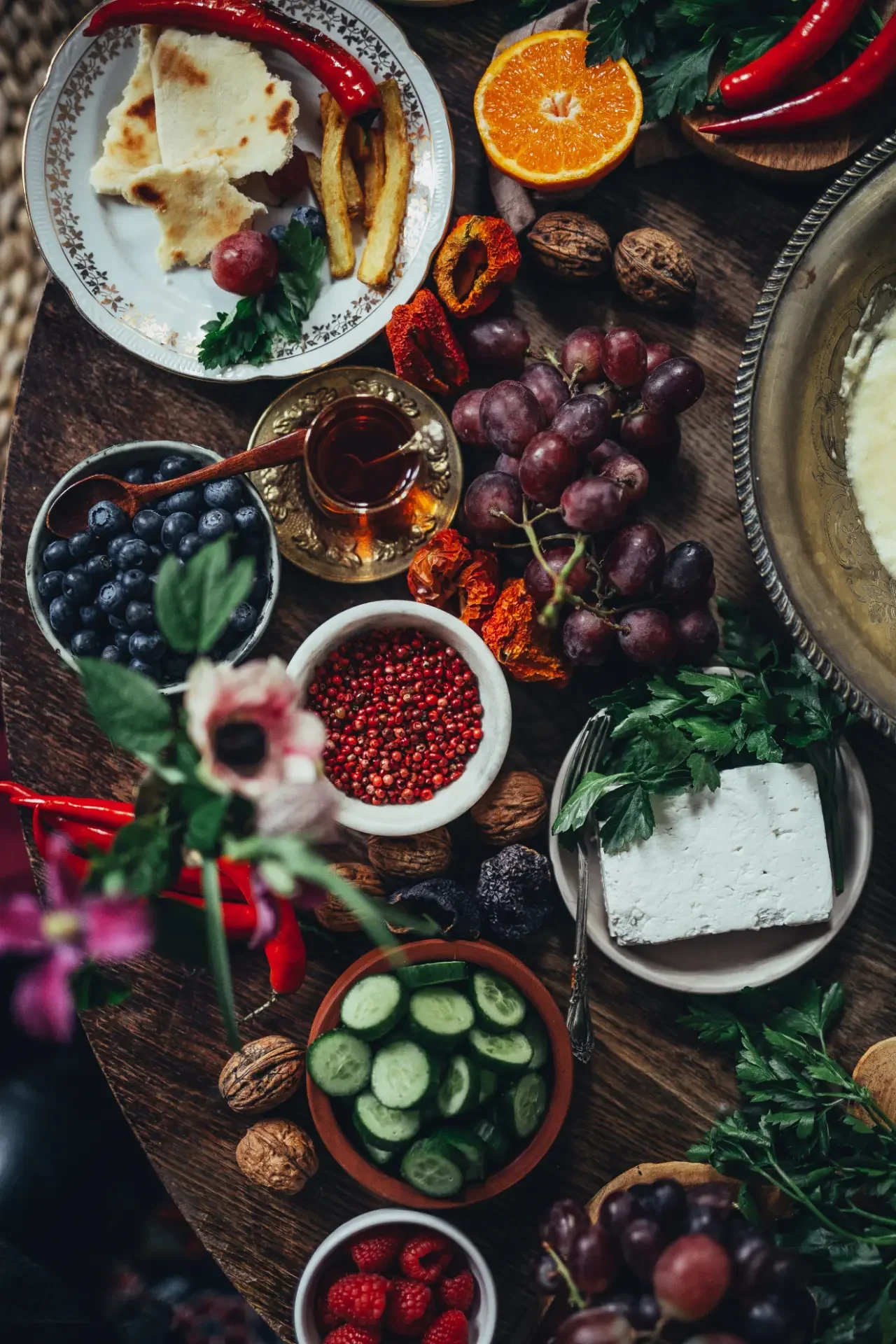 Fresh herbs, vegetables and mezze ingredients arranged for Mediterranean feast
