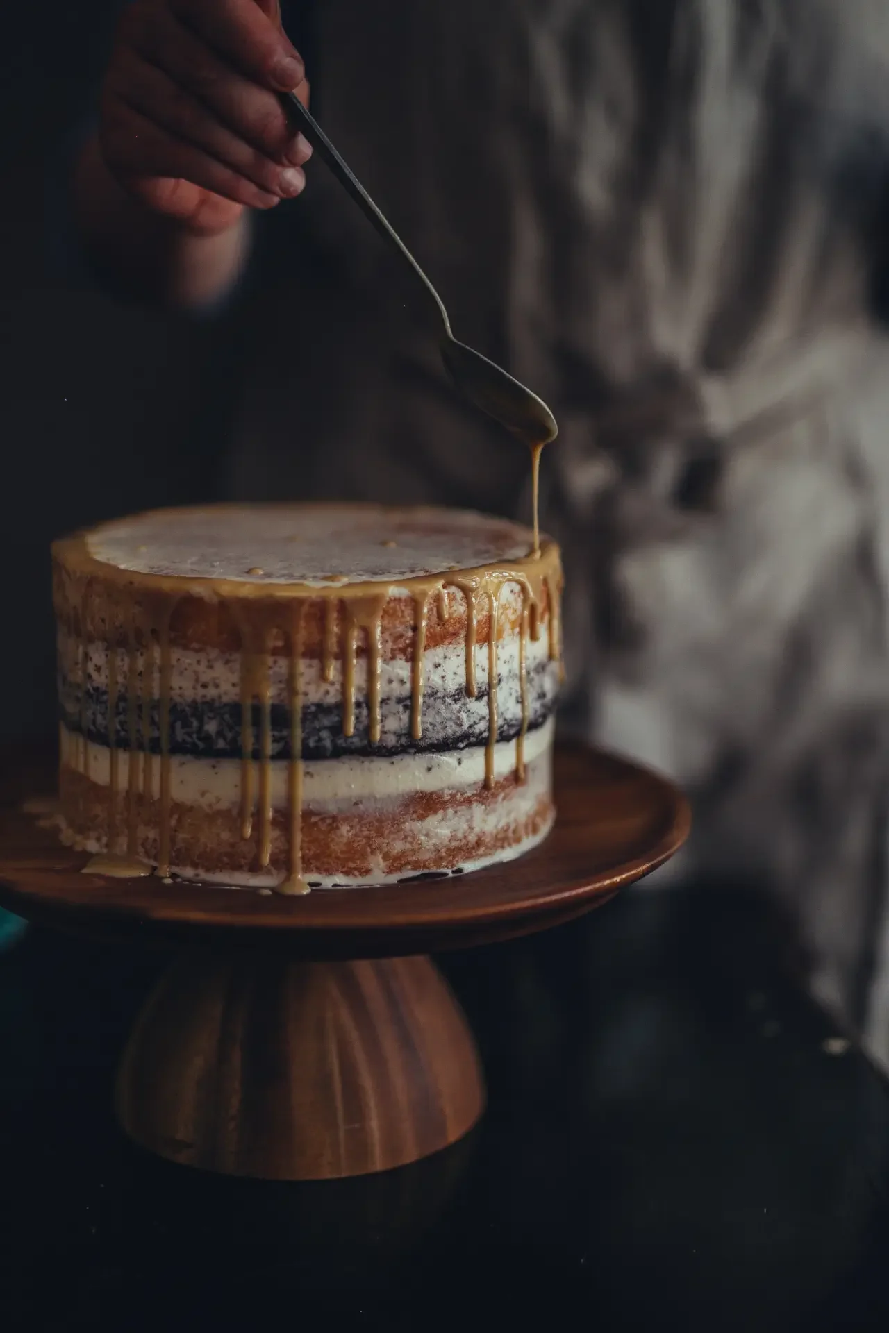 Layered tahini cake coated with cream and toasted sesame seeds