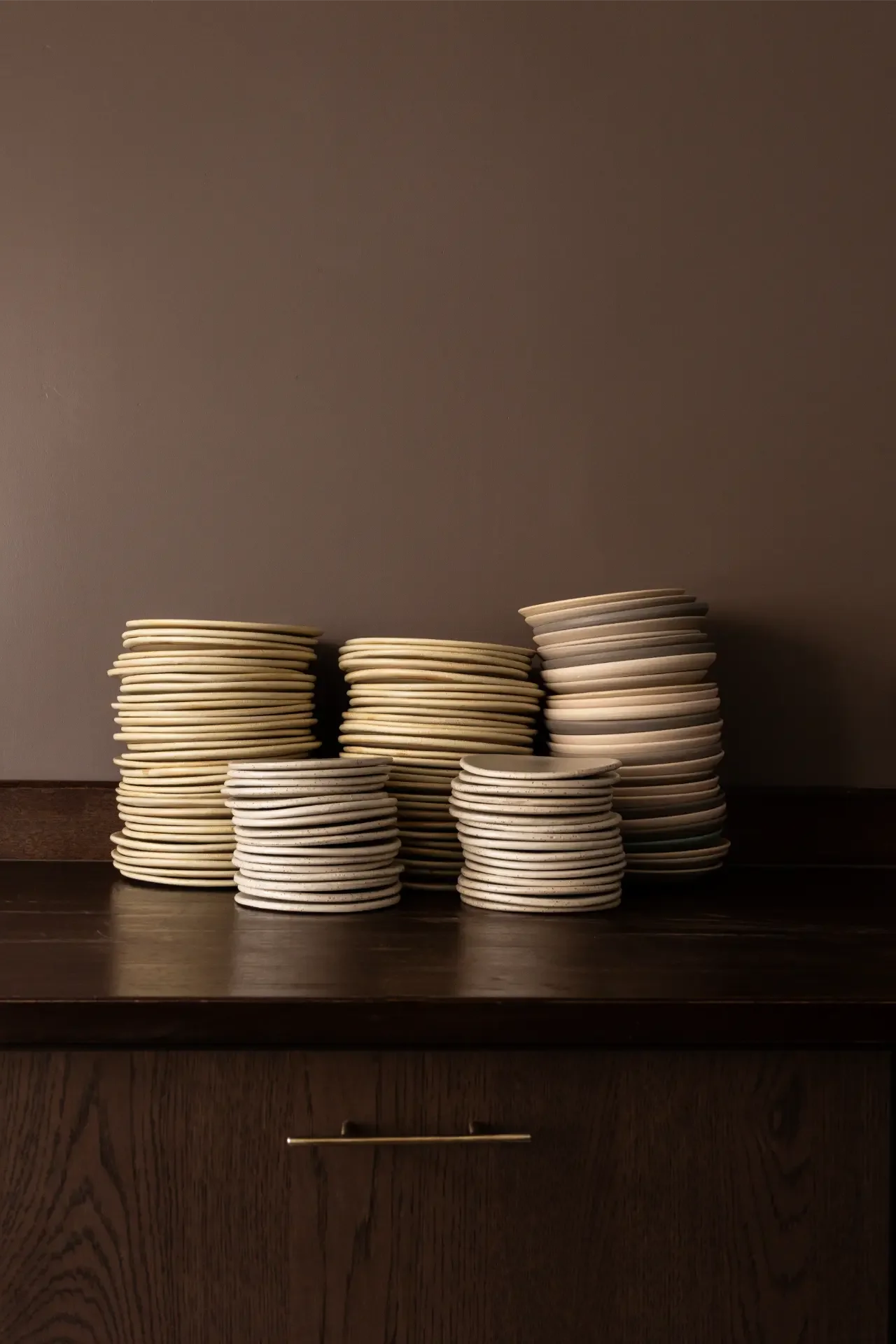 Stacked handcrafted plates displayed on wooden table at Dilekerei