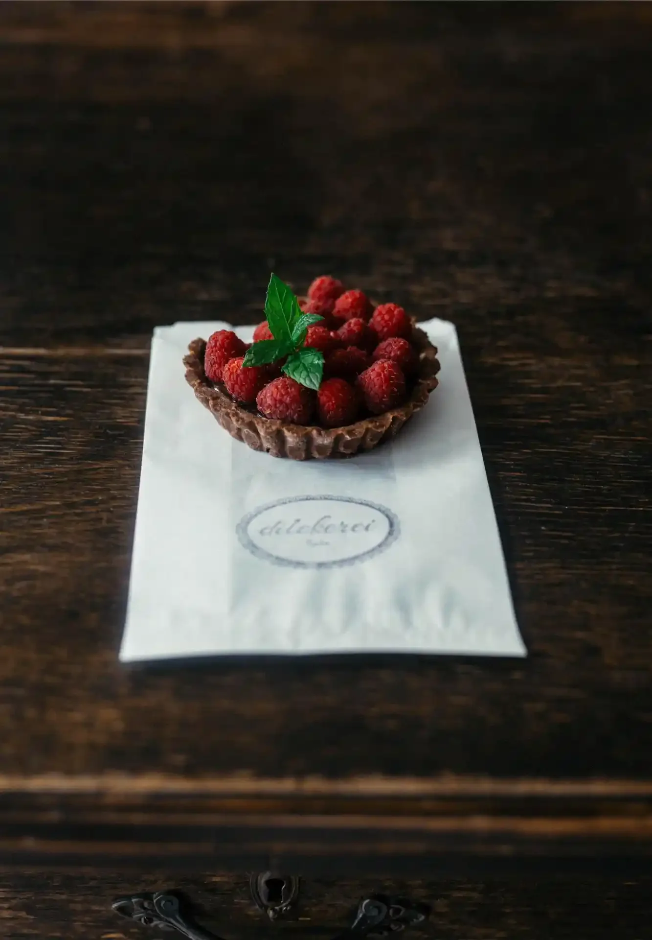 Chocolate cheesecake tarte topped with fresh raspberries and mint