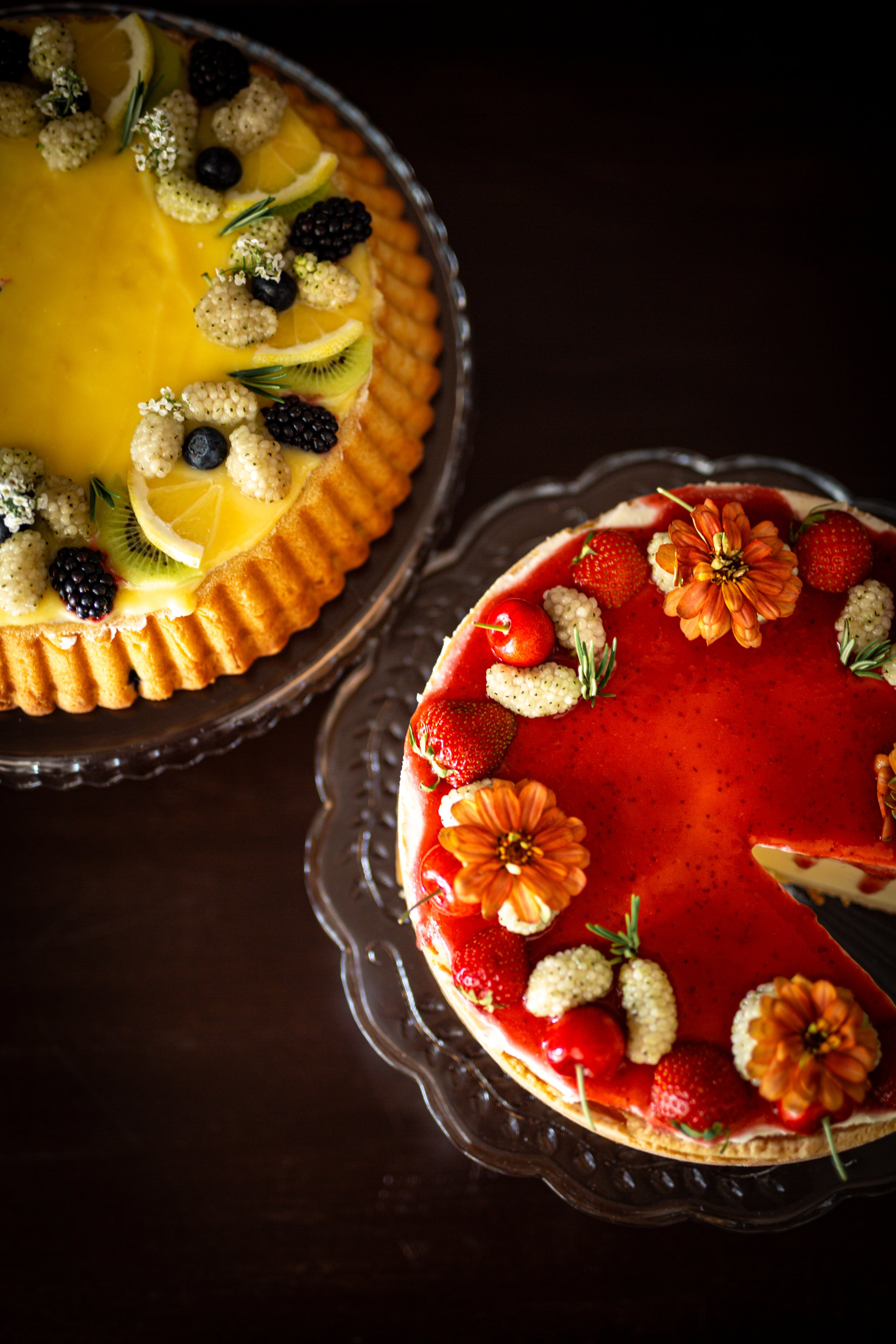 Colorful fruit tartes decorated with fresh berries, apricots and seasonal fruit