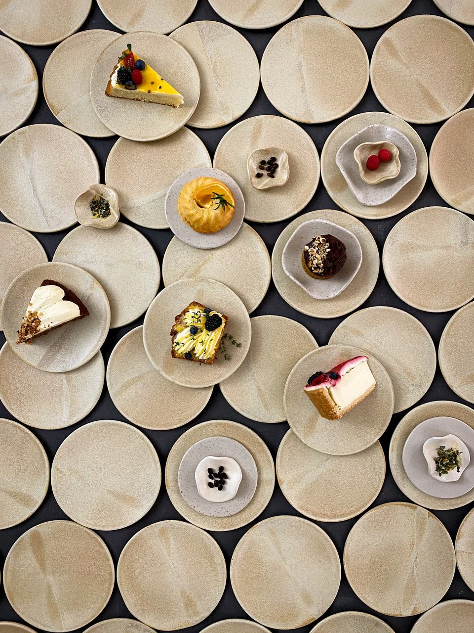 Overhead view of handcrafted cake and pastry selections served on artisan ceramic plates at a dilekerei private event — Berlin