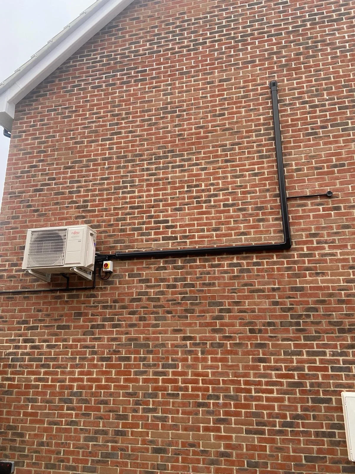 The outdoor unit of a wall mounted split air conditioning system project, with trunking and power feed