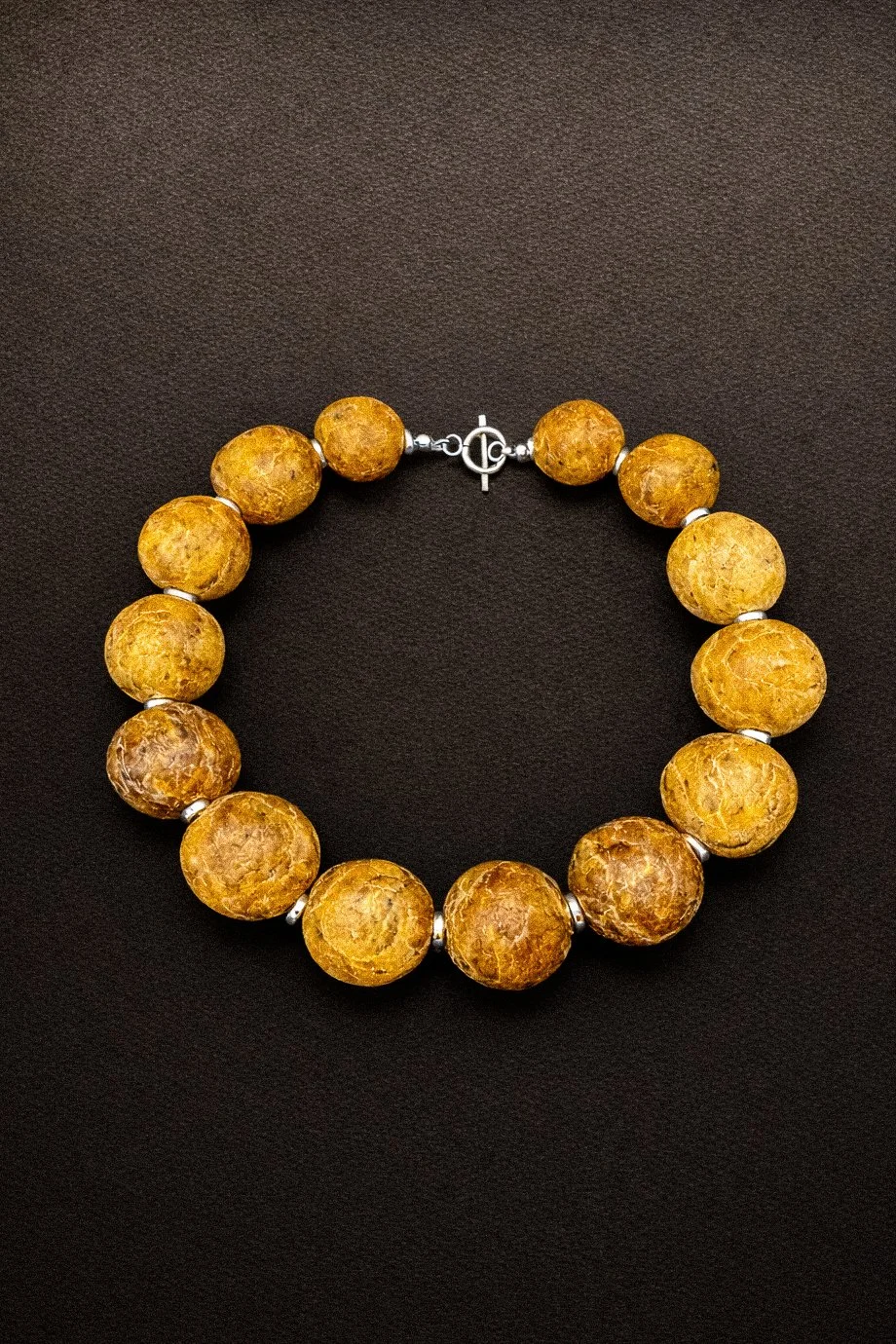 Bracelet avec de grosses perles jaunes et une fermeture en métal.