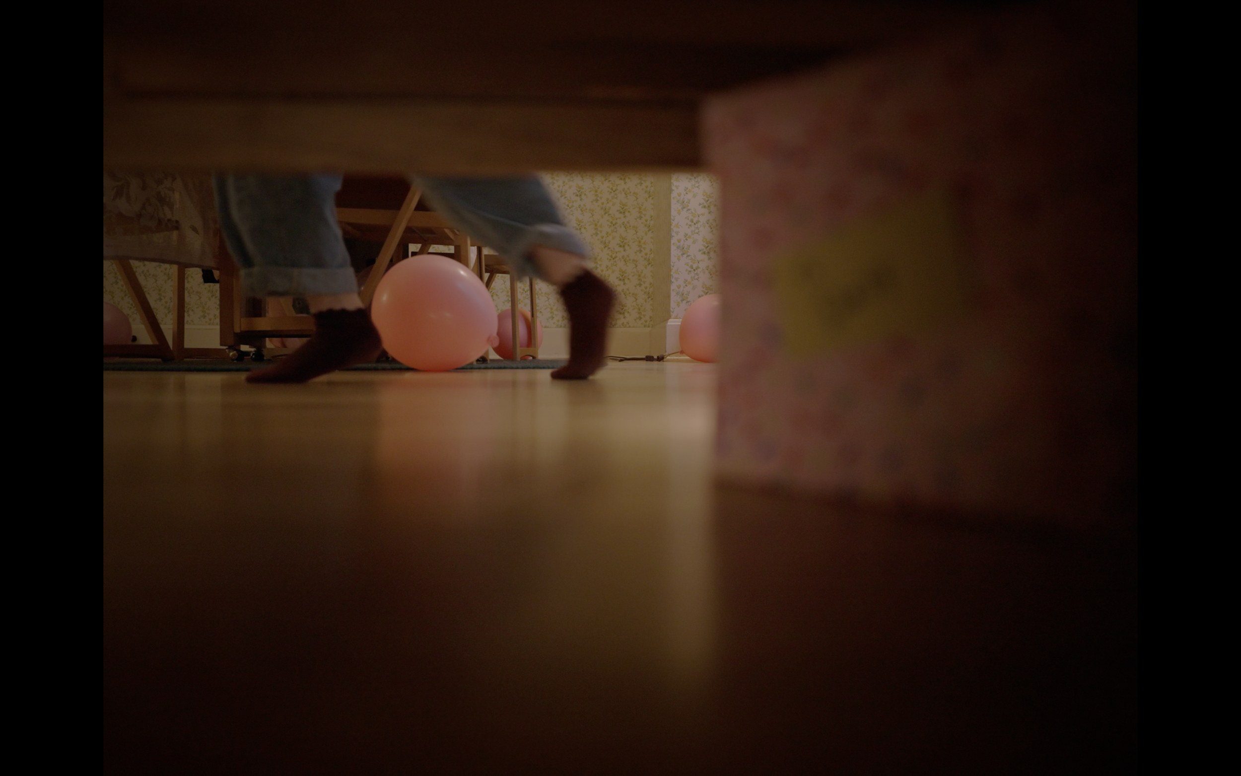DAISY, a little girl, has found her birthday presents and is tearing them open by herself.