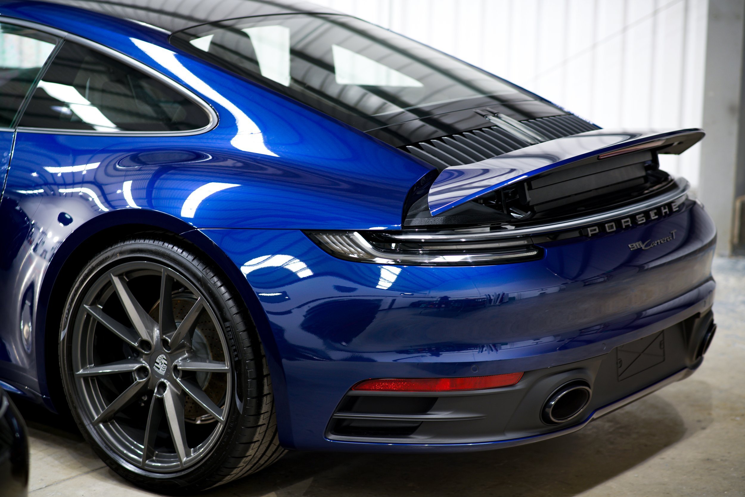 Close up of Porsche 911 Carrera T side in Gentian Blue Metallic with factory gloss paintwork and original Carrera T livery before matte PPF conversion at Lucid PPF Leeds