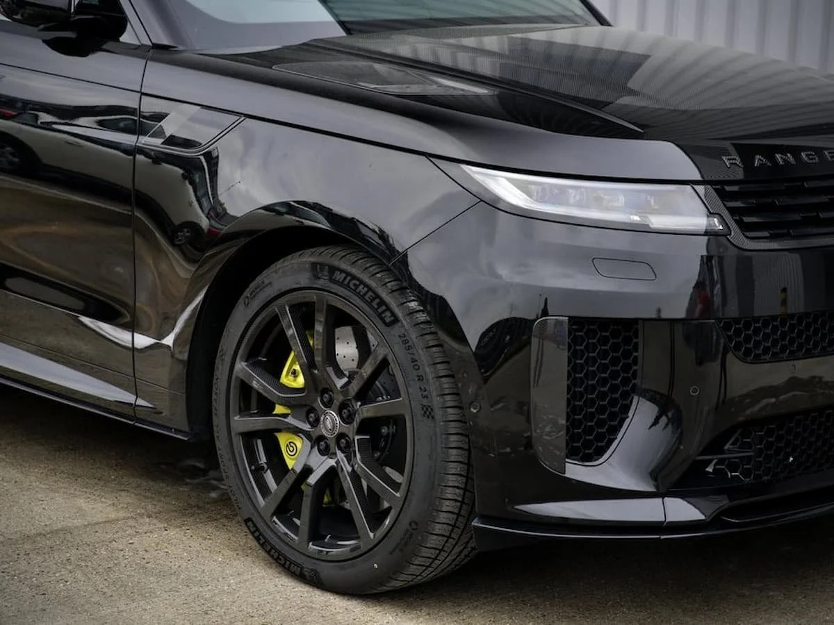 Close up of Range Rover Sport SV Edition One front quarter with original gloss black paint and carbon fibre bonnet before matte PPF installation
