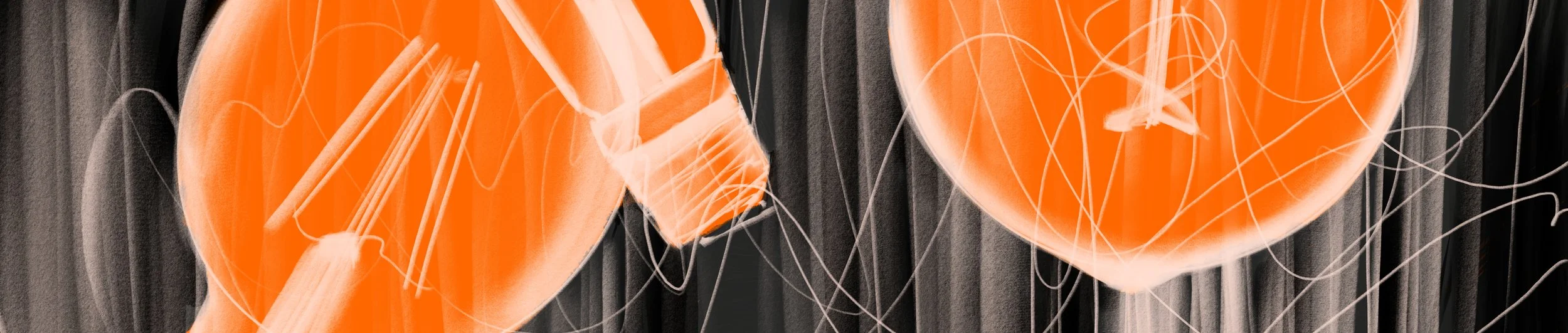 Close-up of a hanging light fixture with multiple orange glass panels and thin metal wires.