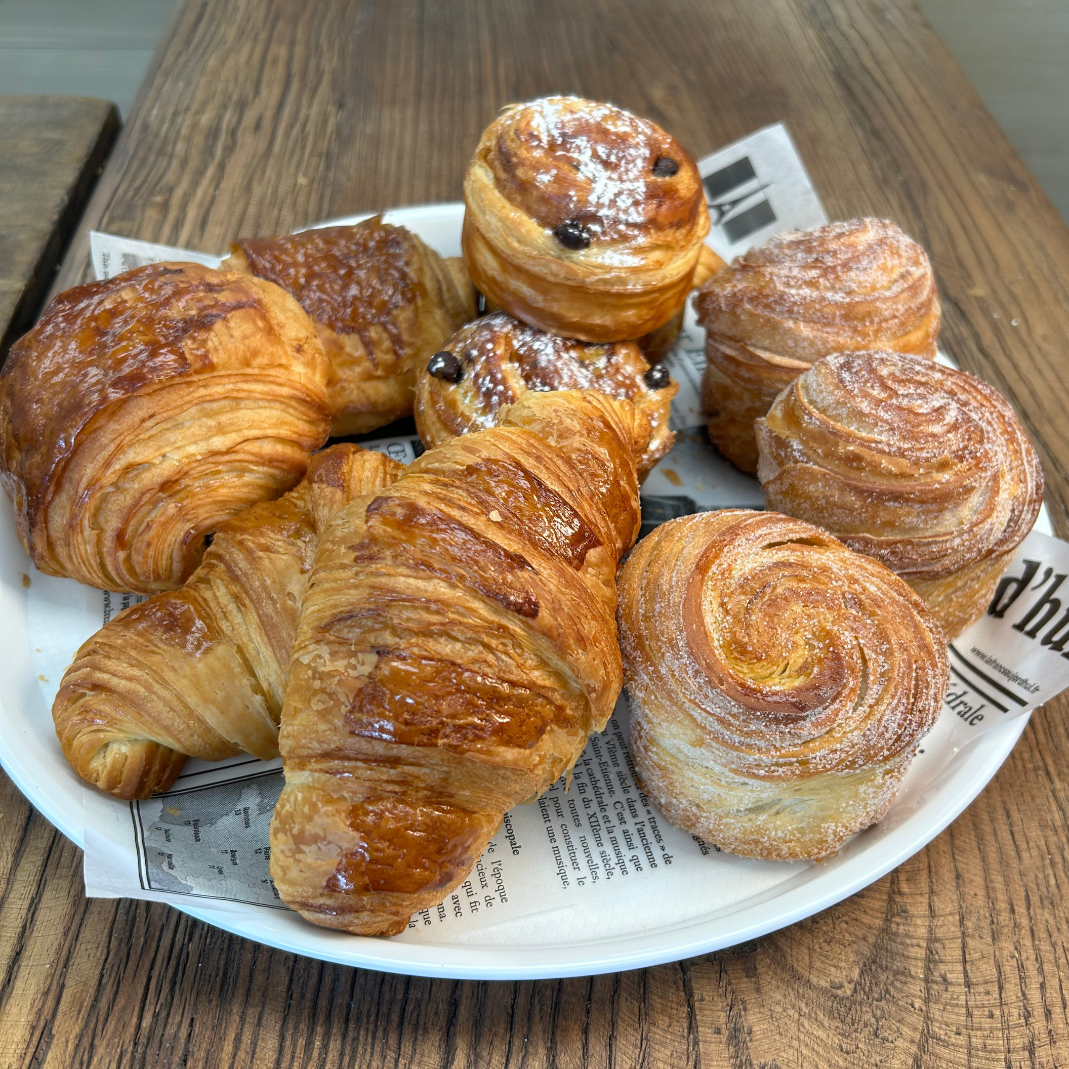 a plate with croissants and cruffins and chocolate croissant