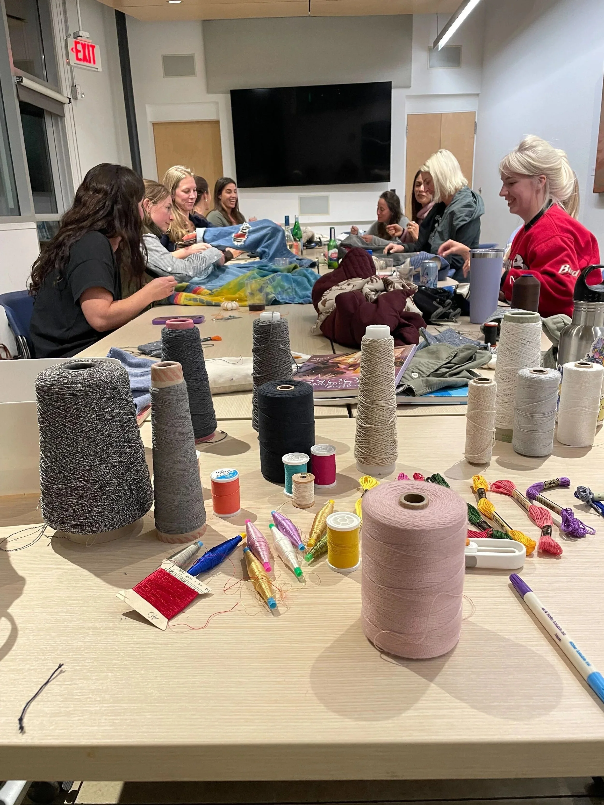 materials and a group of people enjoying stitch night