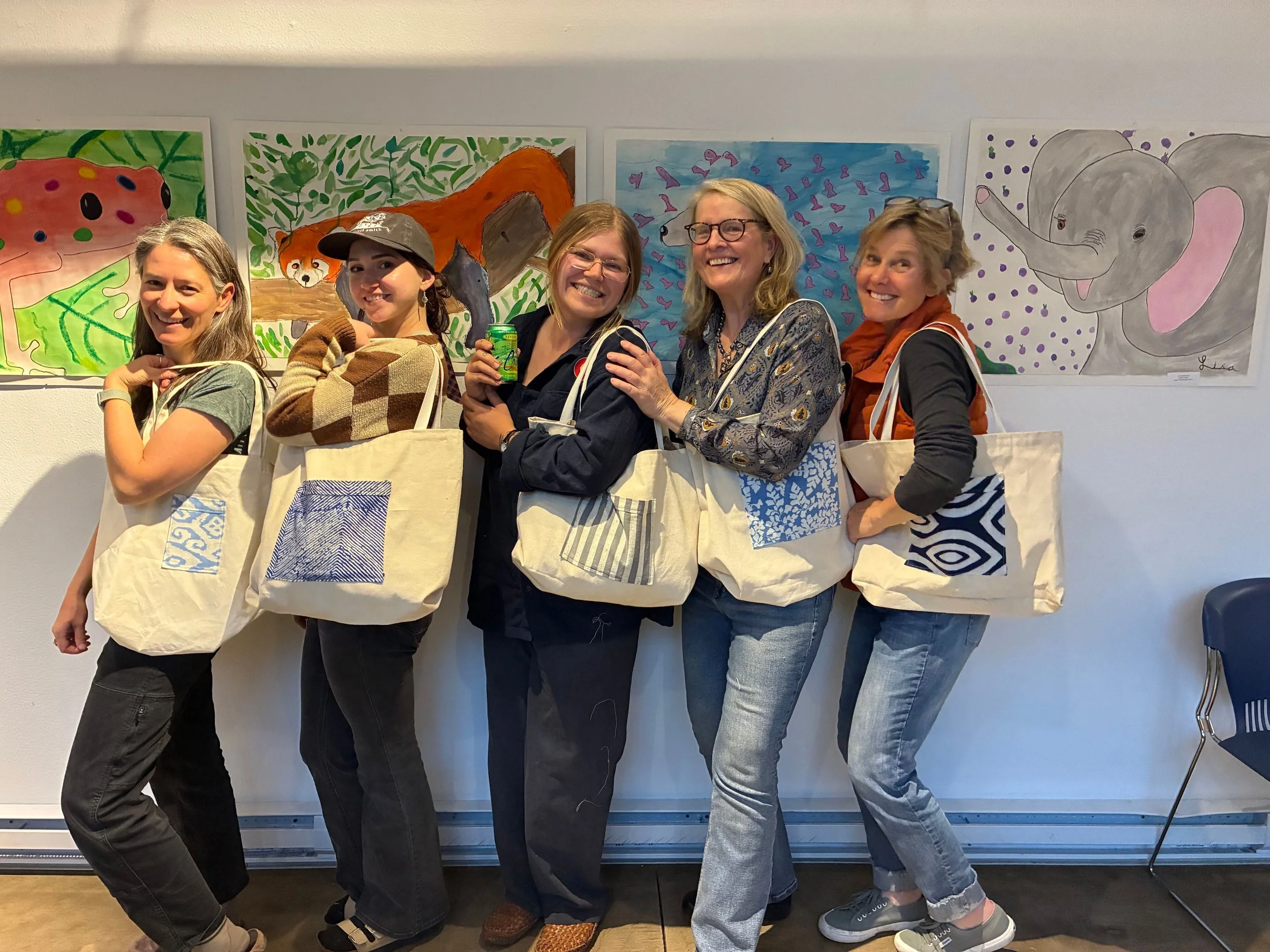 women posing with tote bags that they made