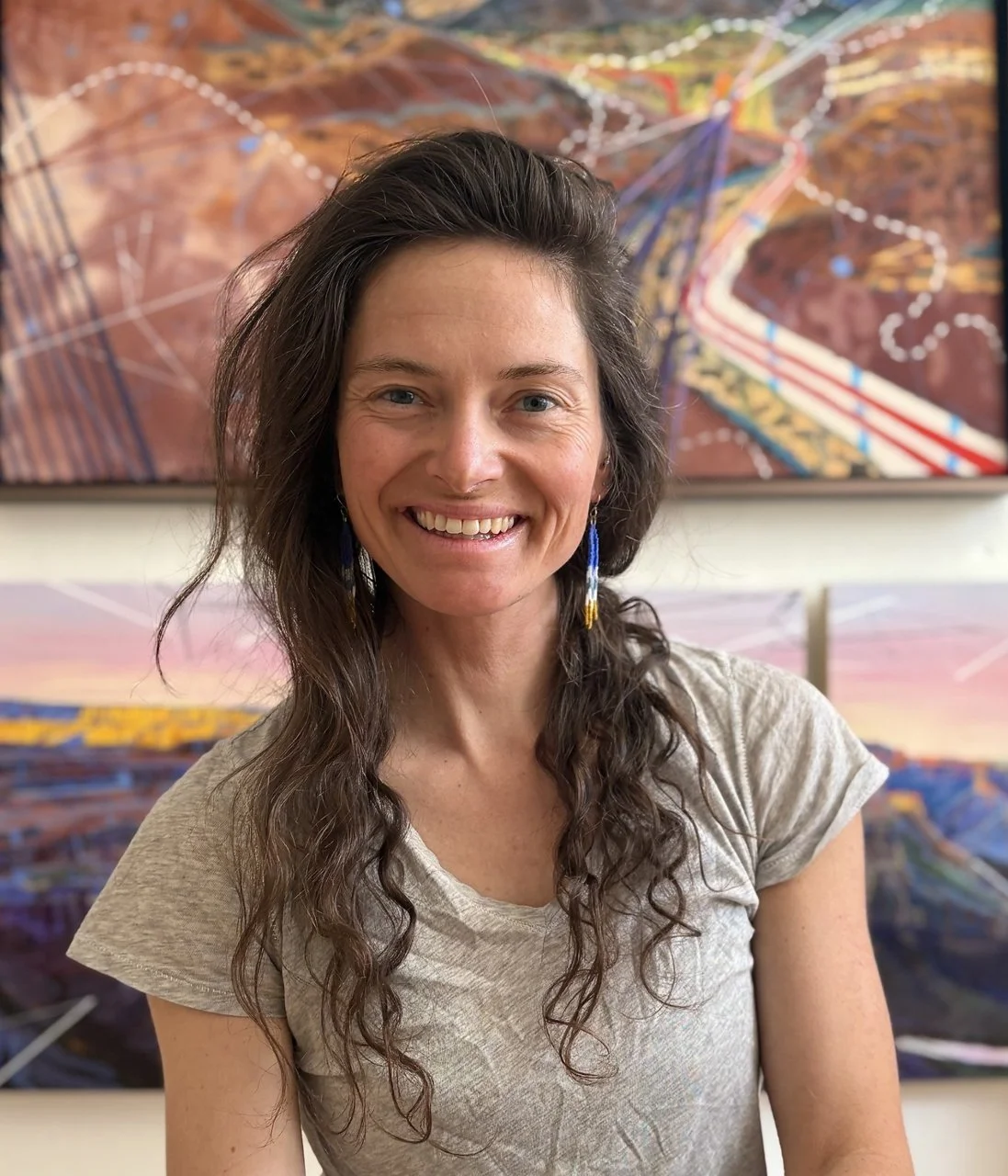 Head shot of Nika Meyers with her artwork in the background