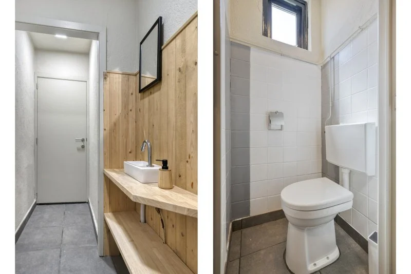 De afbeelding toont een badkamer met twee aparte ruimtes: links een wastafel met spiegel en houten wand, rechts een toilet met wandbehang en klein raam.