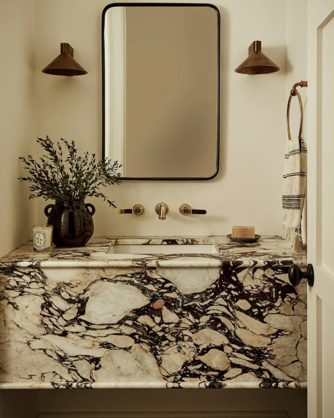 This bold, organic marble vanity by @beccainteriors is the perfect blend of warmth and drama.⁠
⁠
Want to recreate this look? We&rsquo;ll help you find a stone with this much character and cut it to perfection for your space. Let&rsquo;s make your dre