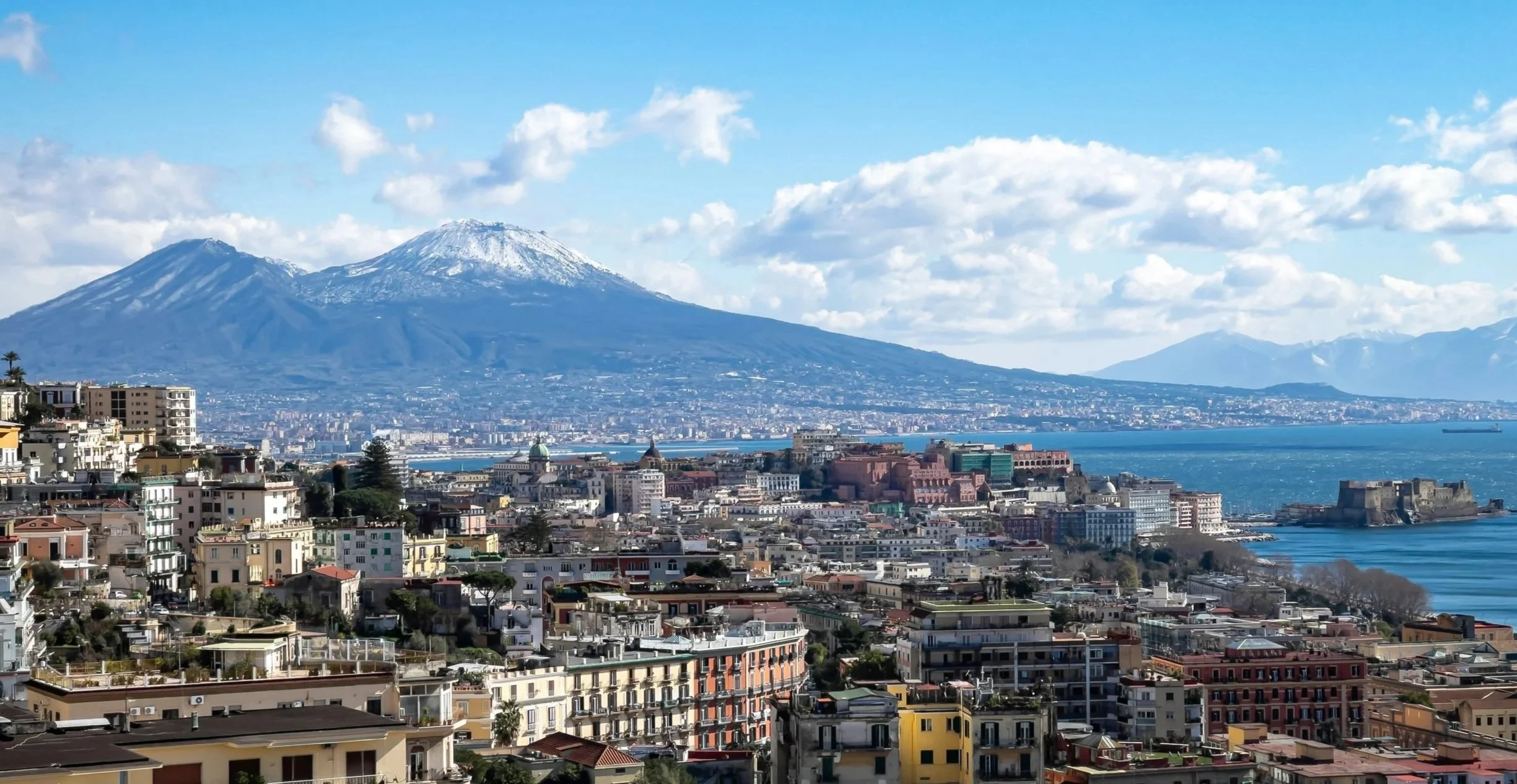 Mount Vesuvius towering over the city of Naples, symbolising the volcanic landscape that shapes Neapolitan cuisine