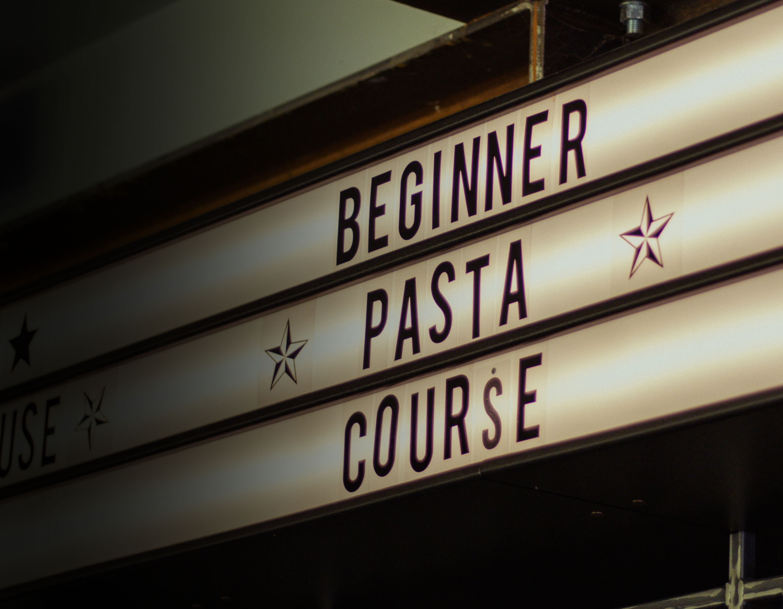 Close-up of a vintage illuminated sign displaying menu items such as 'Beef Niner,' 'Pasta,' and 'Couse,' with a star decoration.