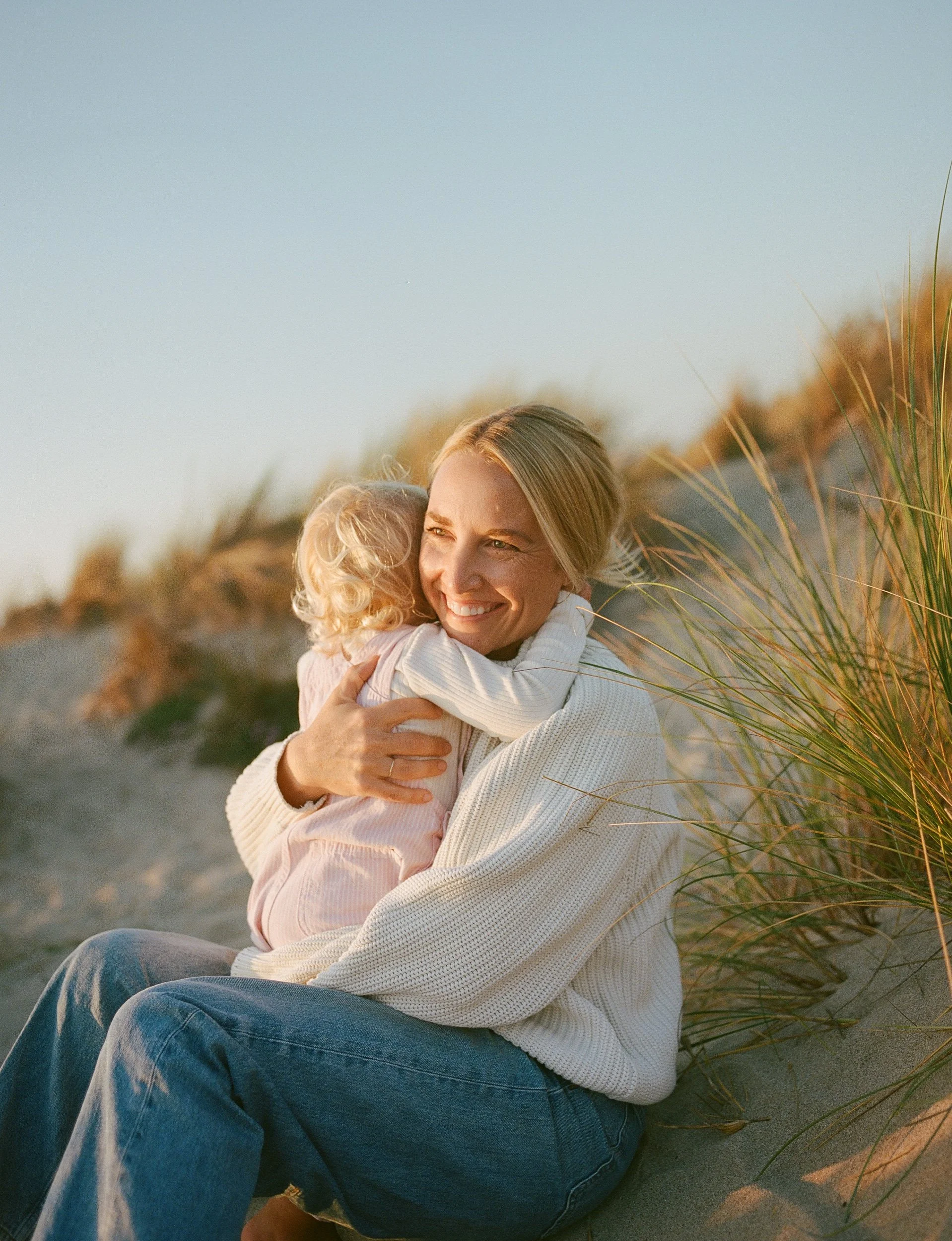 Ojai Wedding Photographer Katie Edwards and her daughter sit on the beach at sunset. Captured on film.