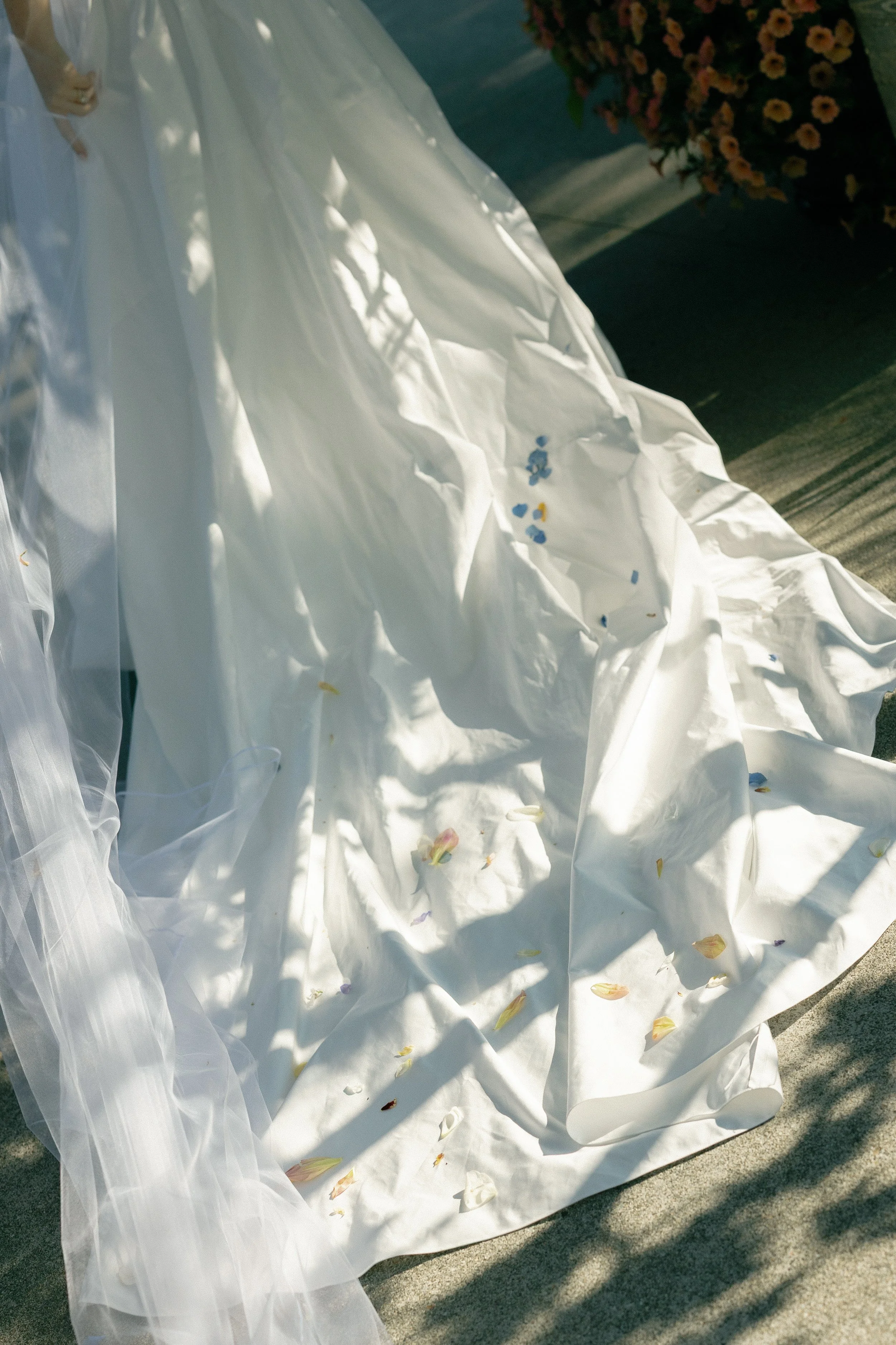Disarrayed white fabric or dress with scattered flower petals, possibly at a wedding or event venue.