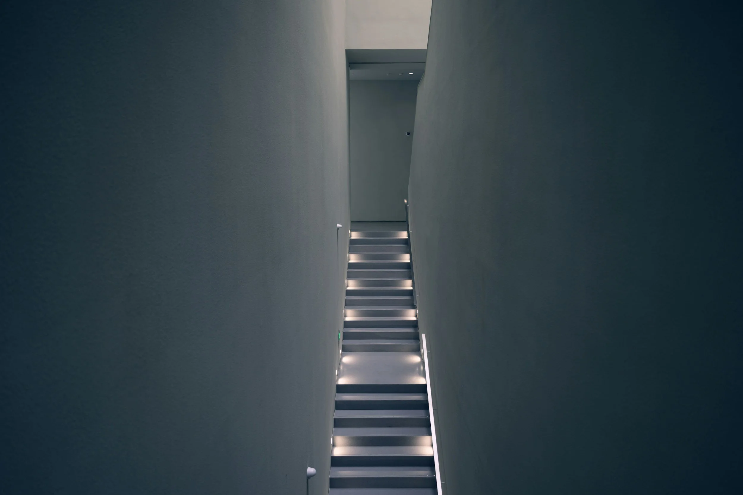 Couloir minimaliste éclairé menant vers une porte