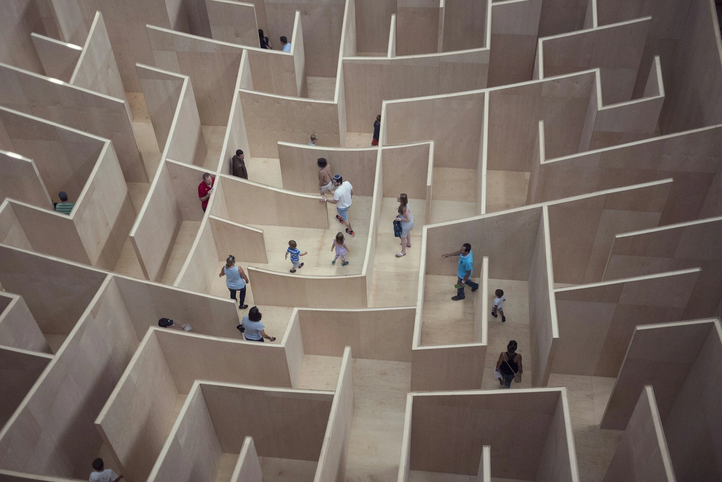 Personnes circulant dans un parcours de cloisons en bois.