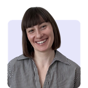 A young woman with shoulder-length brown hair and bangs, smiling, wearing a striped shirt, against a light background.