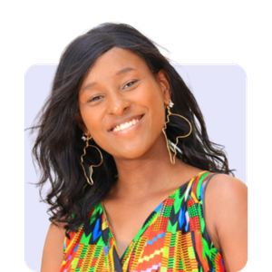 A smiling woman with long black hair wearing colorful, patterned dress and large earrings.